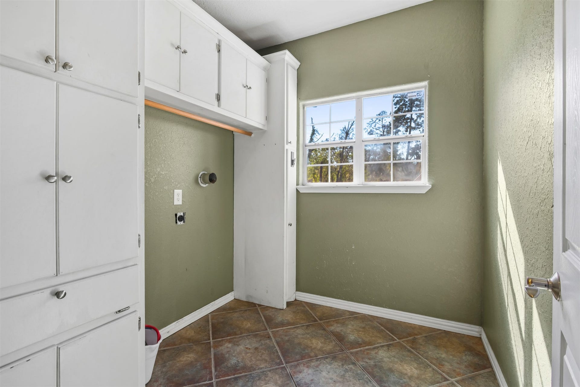 Utility room features wall of built in storage and cabinets.