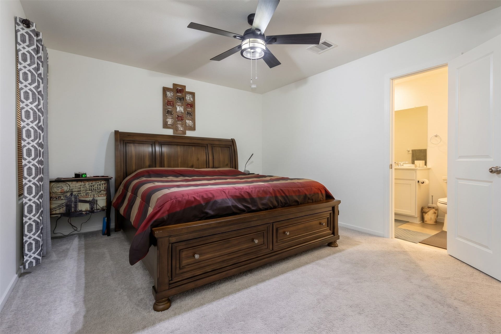 5806 Standpiper Loop, Baytown, TX 77521 Tucked away for optimal privacy, the spacious primary suite features a beautiful layout, custom blinds, a cooling ceiling fan, and an en-suite bath.