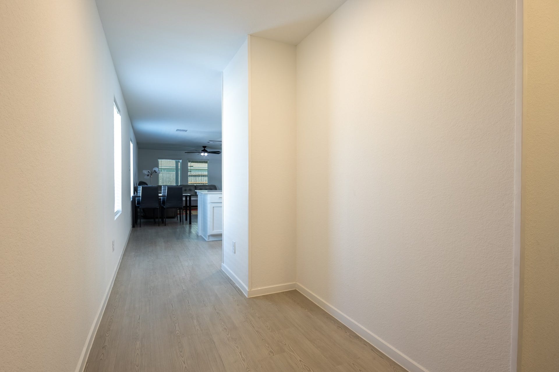 5806 Standpiper Loop, Baytown, TX 77521 A seamless, extended entry hallway boasting durable, modern flooring that guides you gracefully into the heart of the home's open-concept layout.