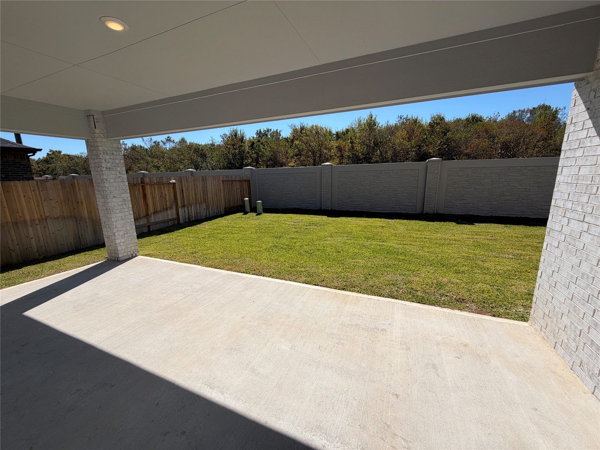 3428 Summercrisp Hollow Lane, Pearland, TX 77581 Spacious backyard with a covered patio, perfect for outdoor entertaining, surrounded by privacy fencing and lush greenery.