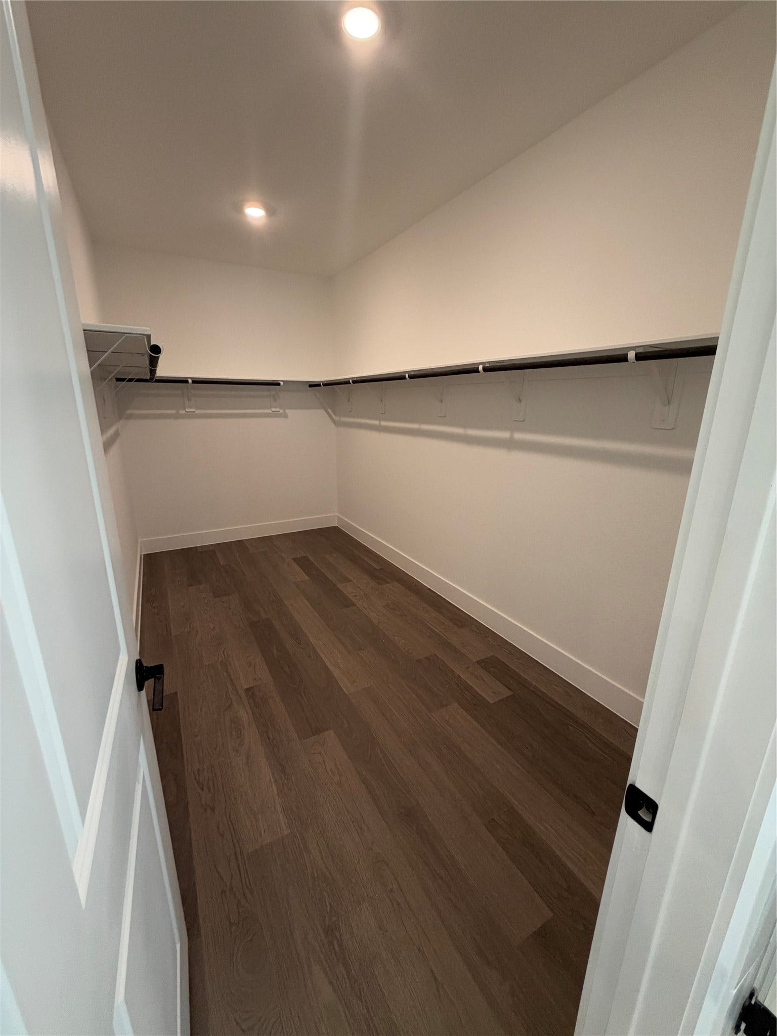 3428 Summercrisp Hollow Lane, Pearland, TX 77581 Spacious walk-in closet with sleek hardwood flooring and ample hanging space for all your storage needs.