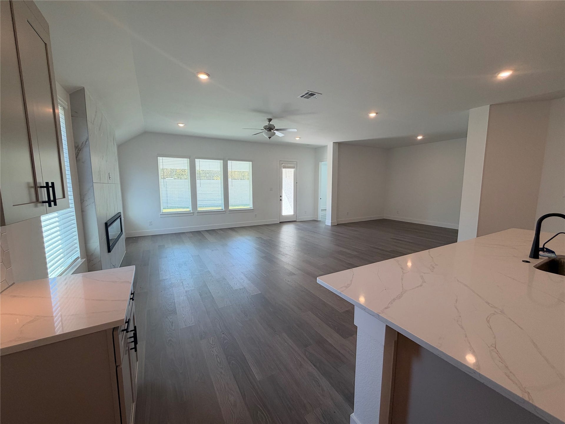 3428 Summercrisp Hollow Lane, Pearland, TX 77581 Spacious open-concept living/dining area with elegant hardwood floors and abundant natural light from large windows.