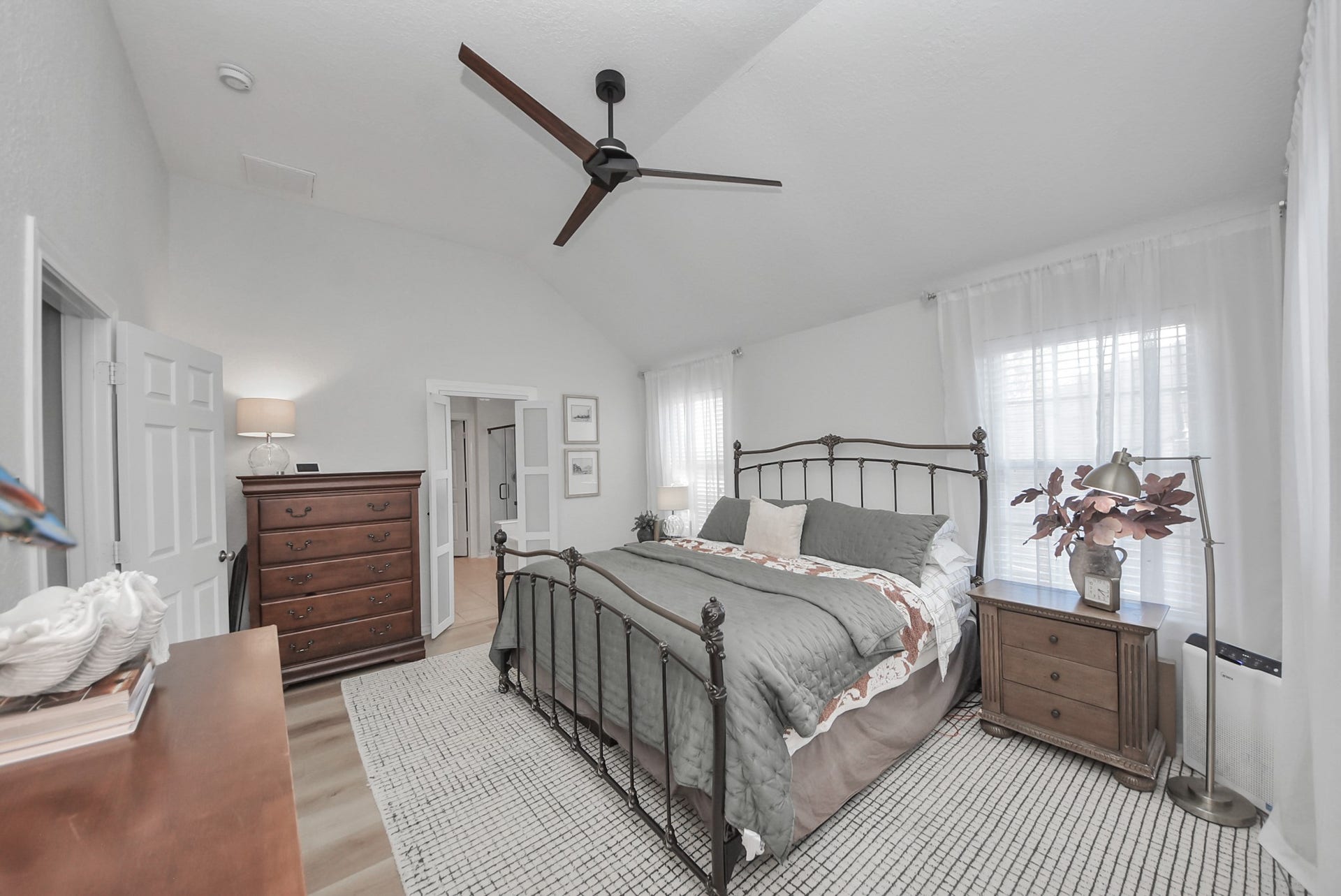 The primary bedroom offers high ceilings, 4 windows for ample natural light, and fits a full bedroom suite - a true oasis!
