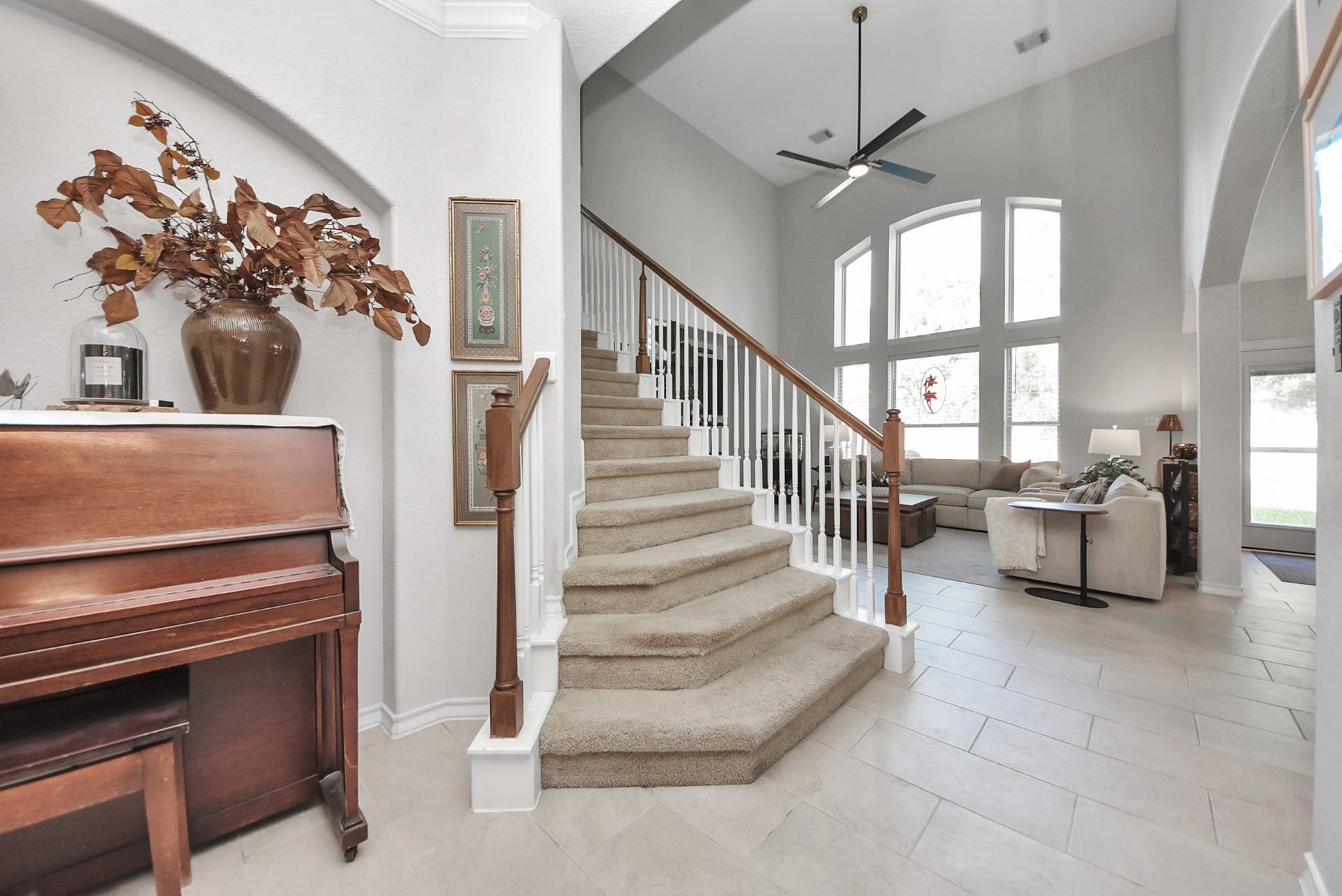 A light-filled entry showcases an elegant staircase, neutral finishes, and an inviting transition into the main living areas.