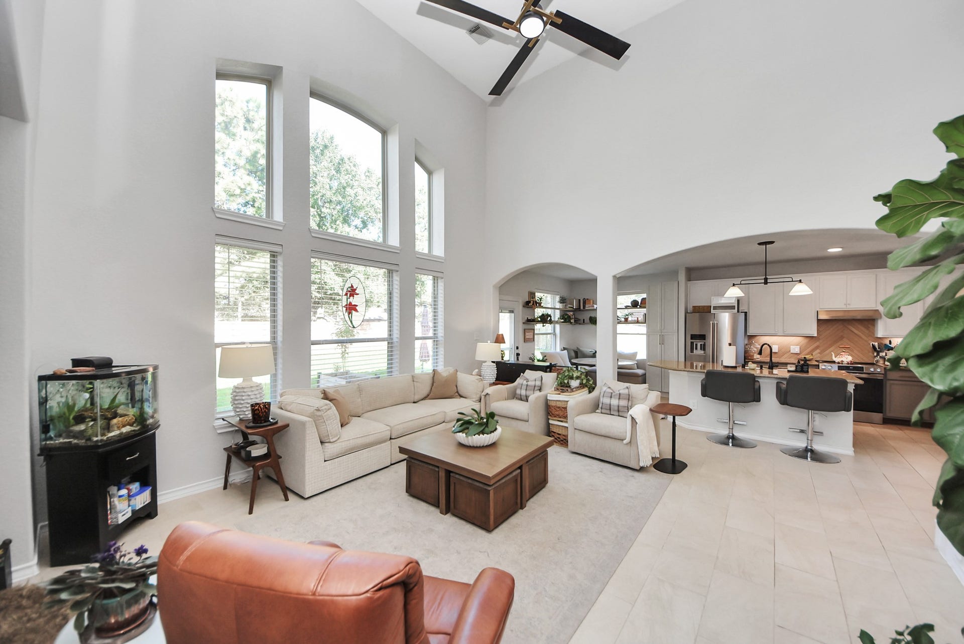 Soaring ceilings, expansive windows, and an open-concept design create a bright, airy gathering space connected to the kitchen.