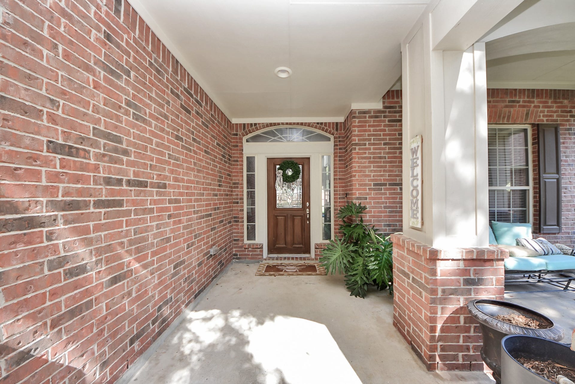 A charming, covered entry welcomes you home with warm brick accents, a beautiful wood front door, and a cozy front porch.