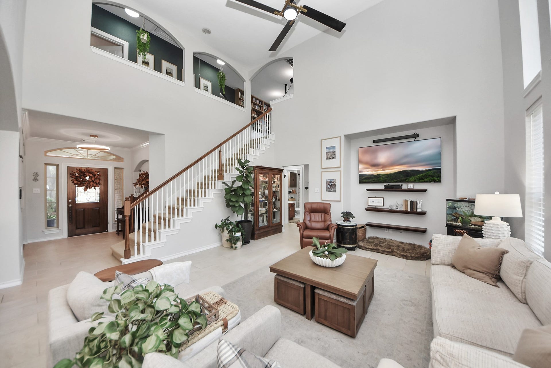 A spacious family room offers an inviting place to relax, with a dramatic two-story ceiling and an open view of the staircase.