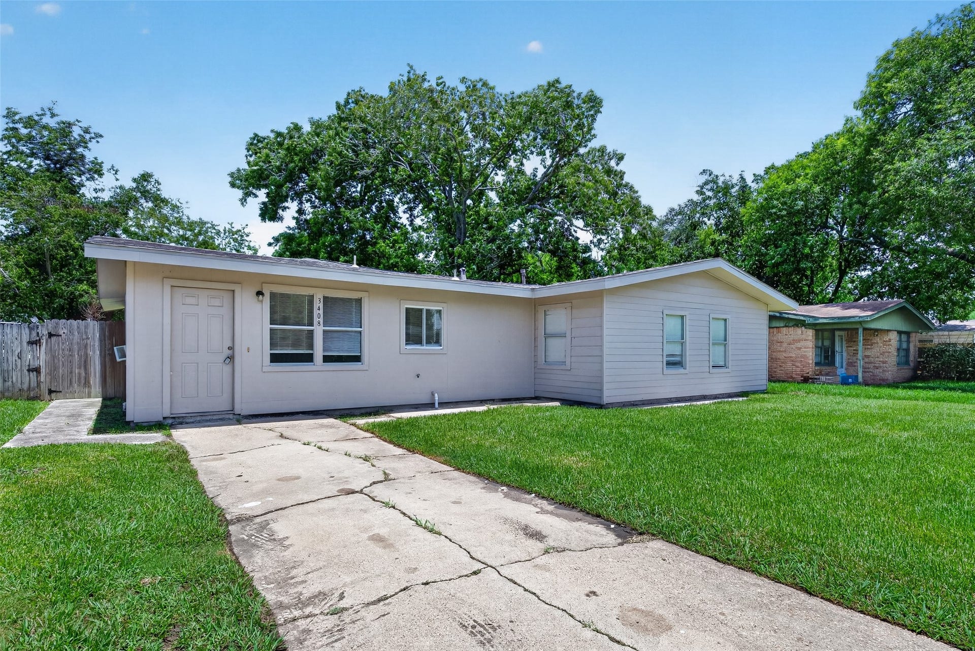 3408 Palm Avenue, Texas City, TX 77590 Discover this charming single-story home featuring a light facade, inviting front porch, and ample windows. Nestled on a grassy lot with a paved driveway, it offers privacy and shade from mature trees.