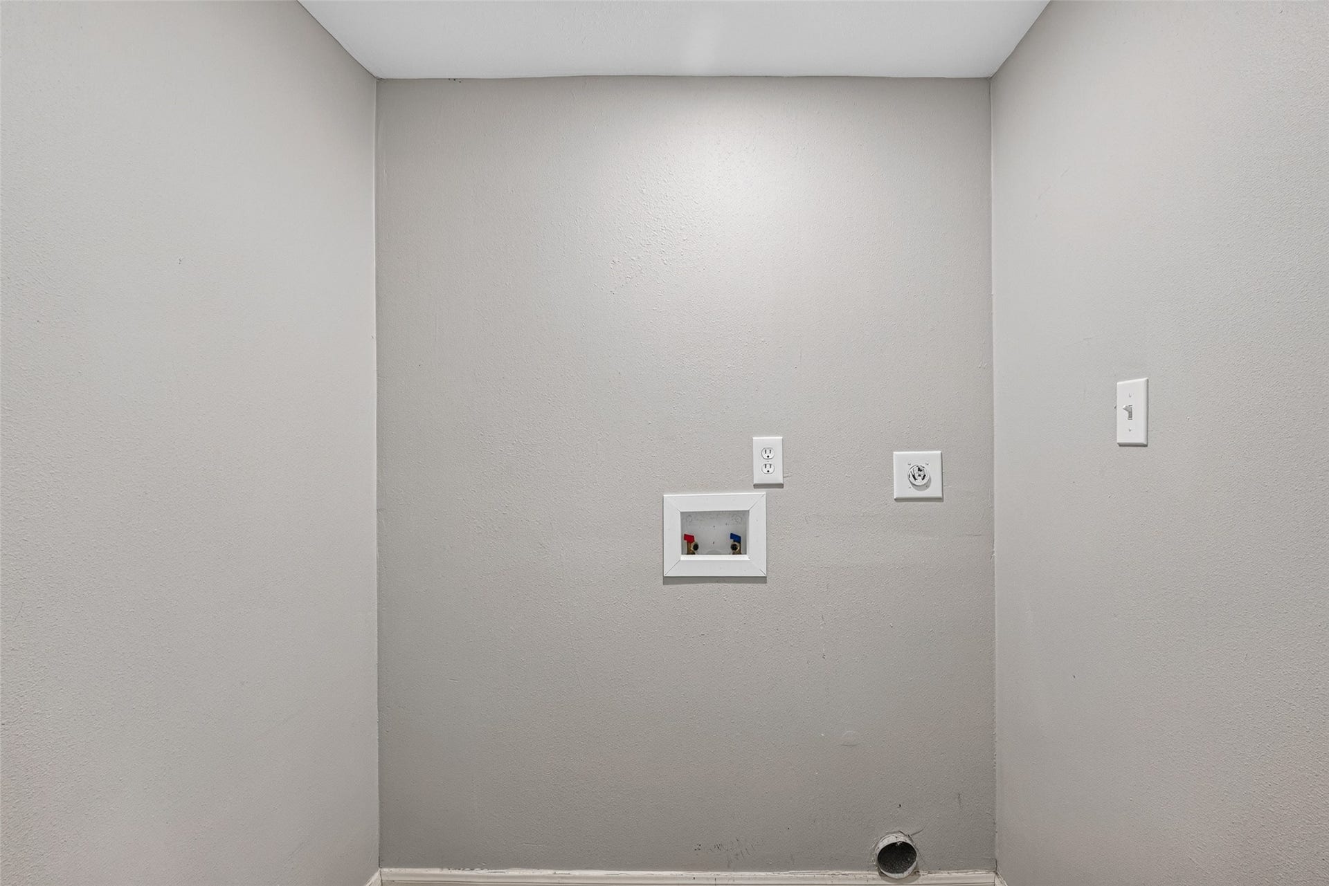 3408 Palm Avenue, Texas City, TX 77590 This image shows a utility area designed for laundry, featuring hookups for a washer and dryer on a plain, light-colored wall.