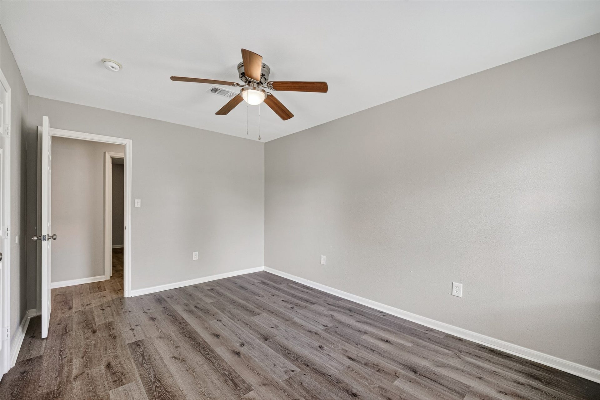 3408 Palm Avenue, Texas City, TX 77590 This room features freshly painted neutral walls, wood-look flooring, and a ceiling fan. It has a simple, clean design, ideal for a bedroom or office space.