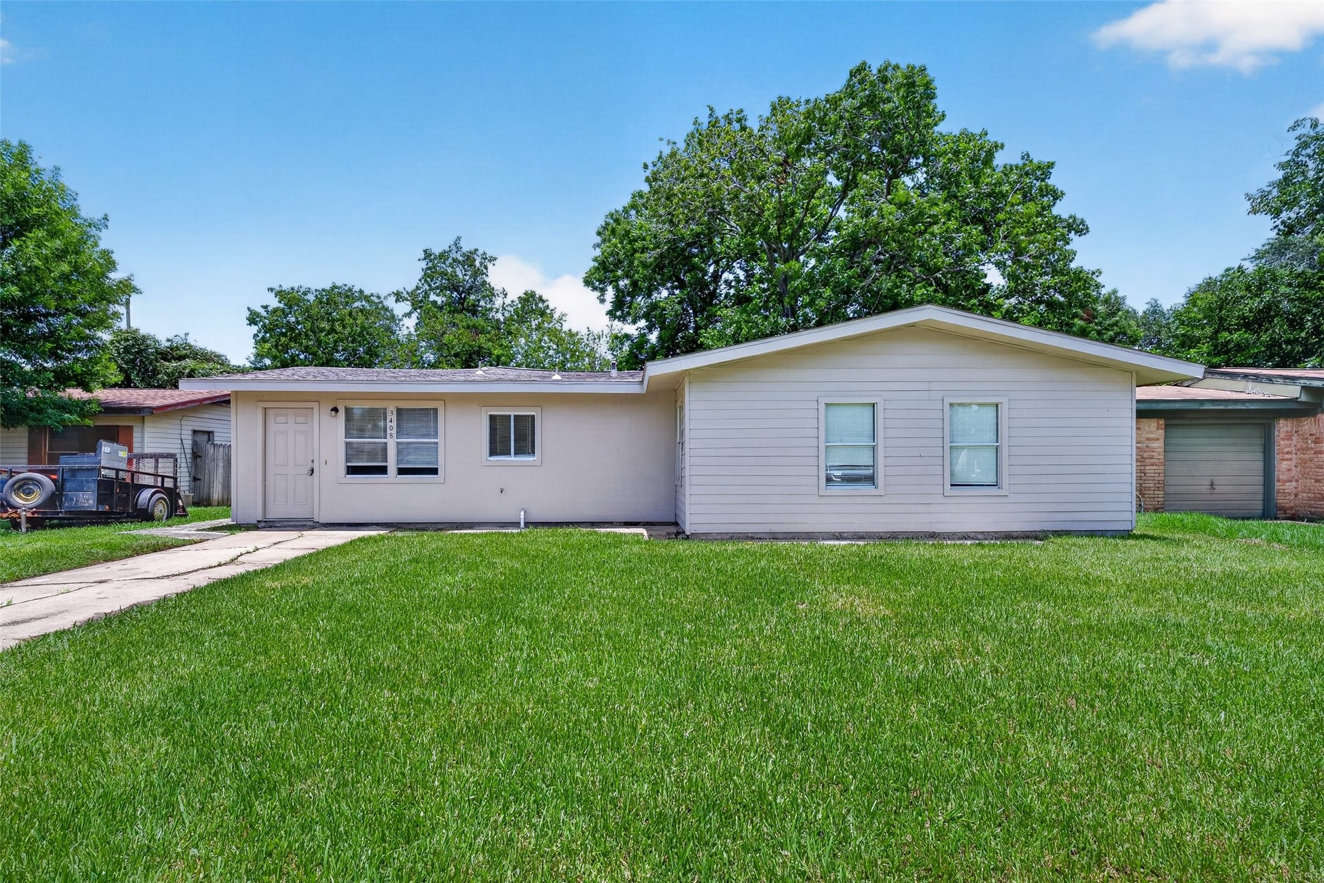 3408 Palm Avenue, Texas City, TX 77590 Charming single-story home with light siding and a pristine lawn. Enjoy a paved walkway to the entrance and the tranquility of mature trees providing natural shade.