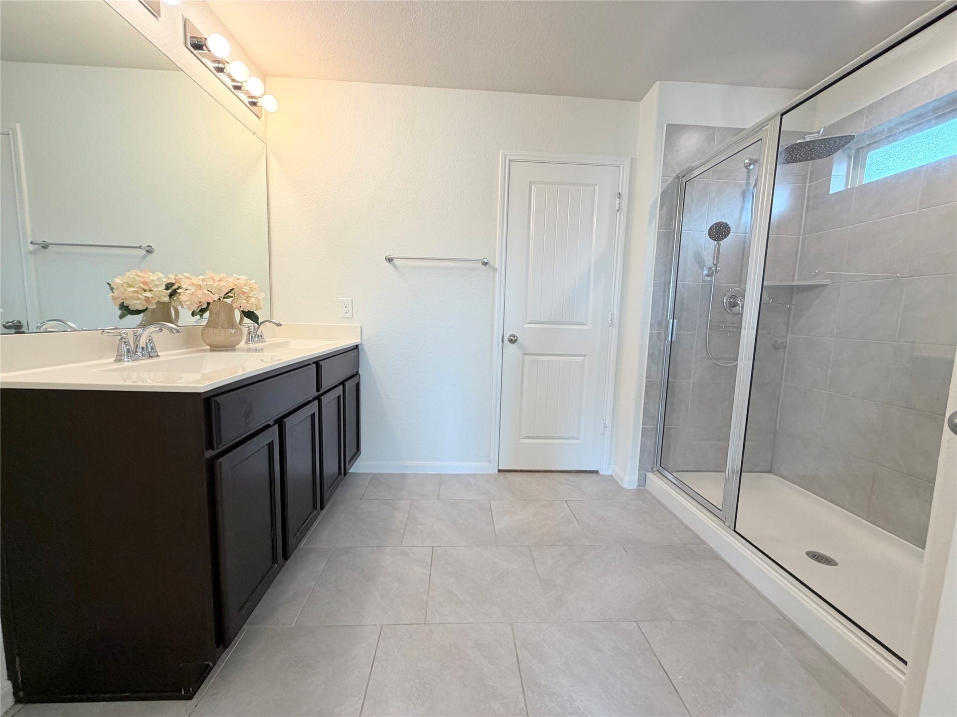 Primary bathroom offers dual sinks and a spacious walk-in shower.