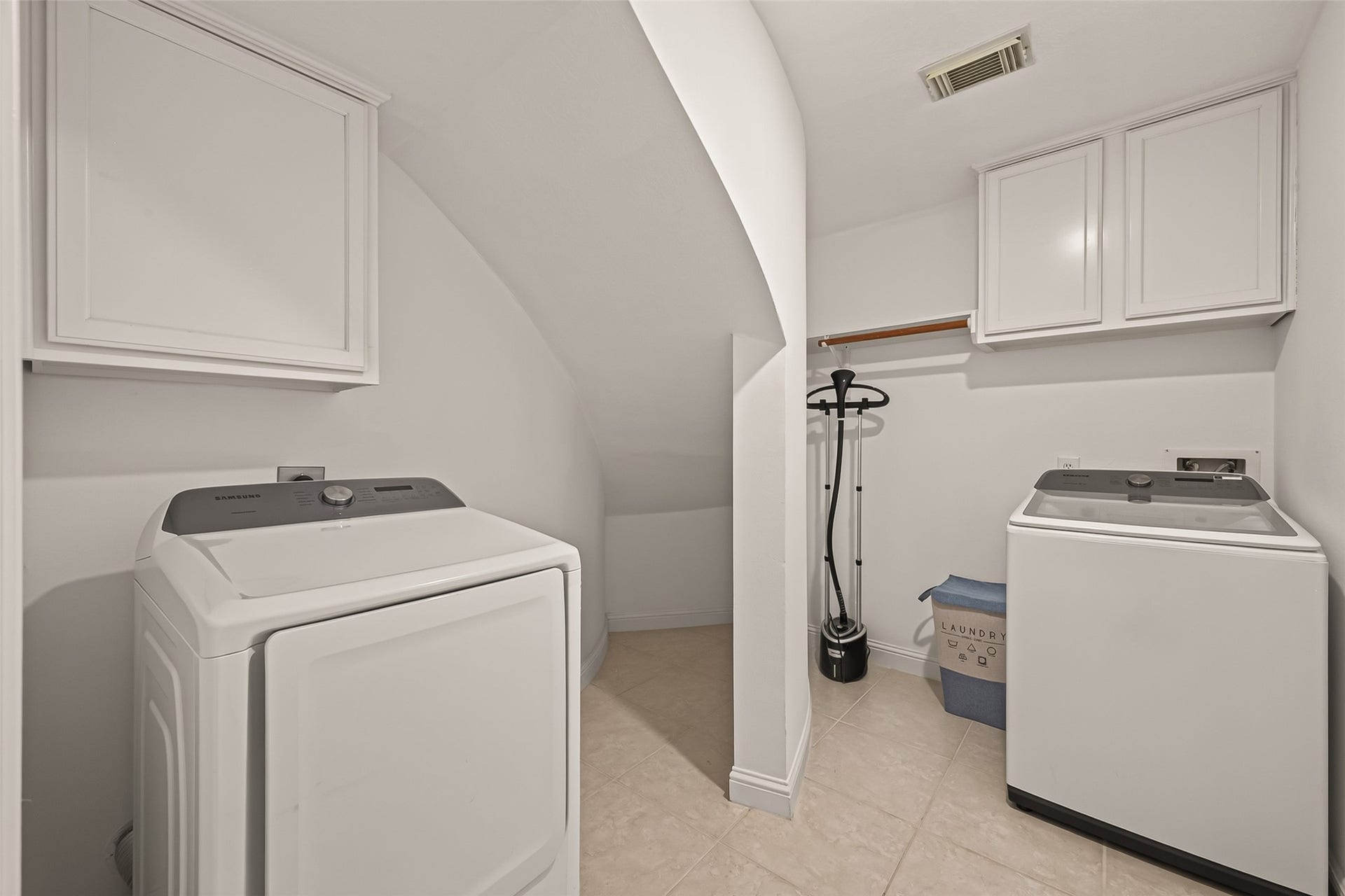 2002 Thorncrest Court, Sugar Land, TX 77479 Spacious laundry room with modern appliances, ample storage cabinets, and a convenient hanging rod.