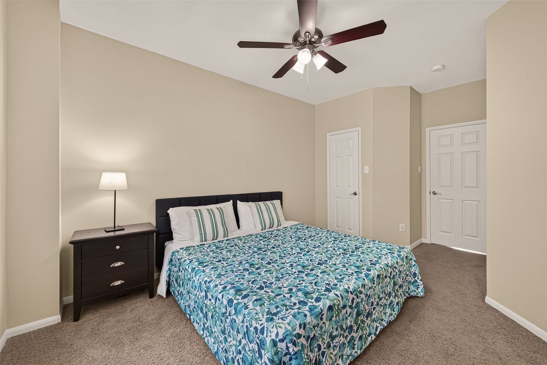 2002 Thorncrest Court, Sugar Land, TX 77479 Cozy bedroom comforter, complemented by a stylish nightstand and warm lighting, all under a modern ceiling fan.