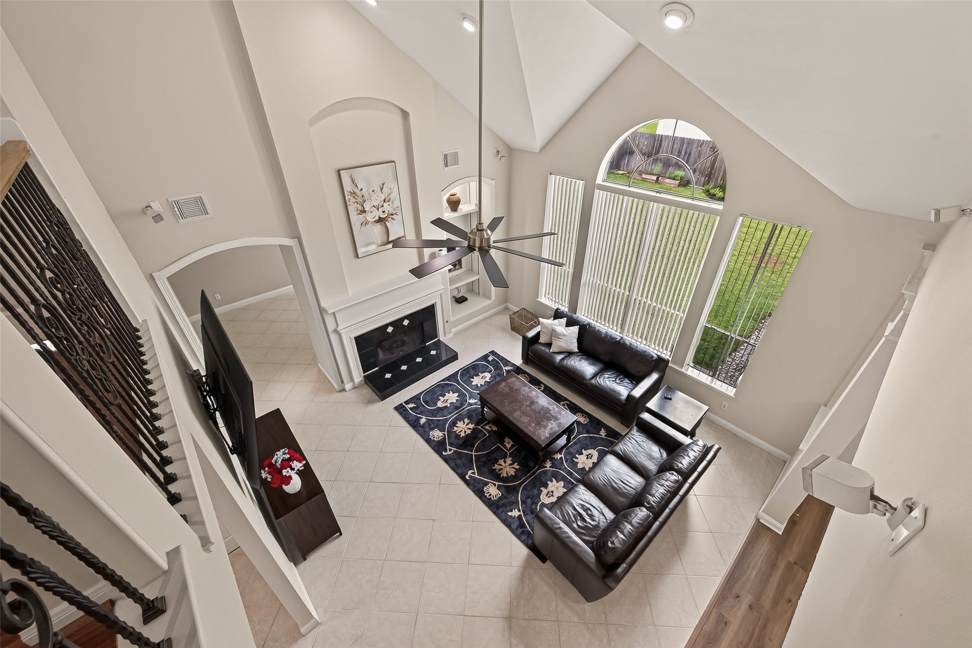 2002 Thorncrest Court, Sugar Land, TX 77479 Spacious living room with soaring vaulted ceilings, abundant natural light from large windows, and a cozy fireplace for a welcoming ambiance.