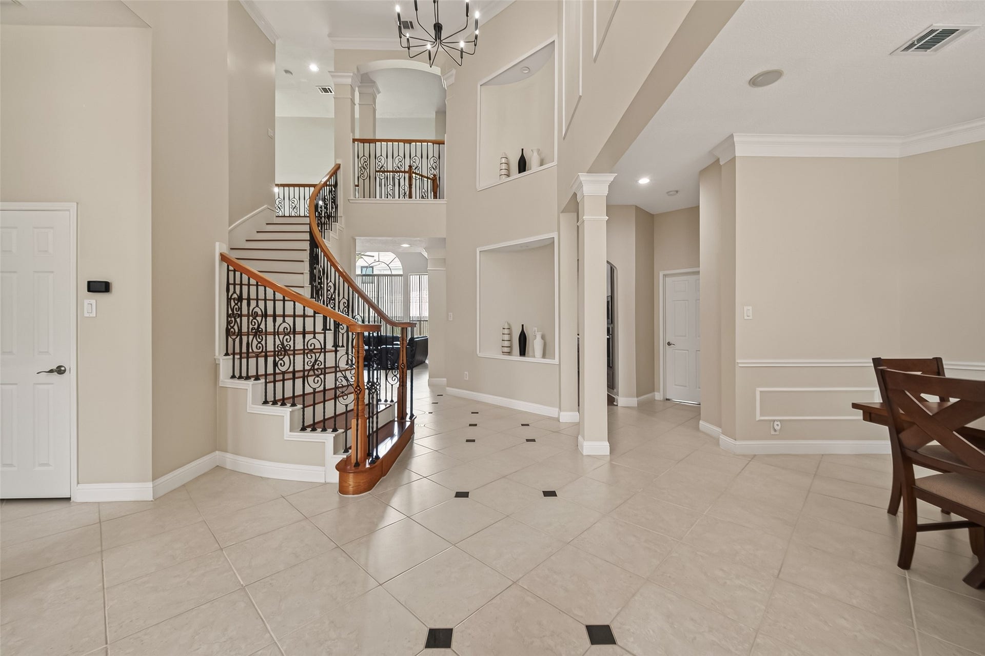 2002 Thorncrest Court, Sugar Land, TX 77479 Staircase with wrought iron railings, complemented by high ceilings and abundant natural light.