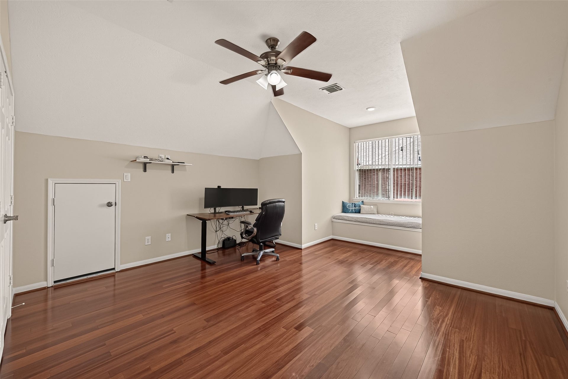 2002 Thorncrest Court, Sugar Land, TX 77479 Spacious room with gleaming hardwood floors, a cozy window seat, and a ceiling fan. Perfect for an office or guest space.