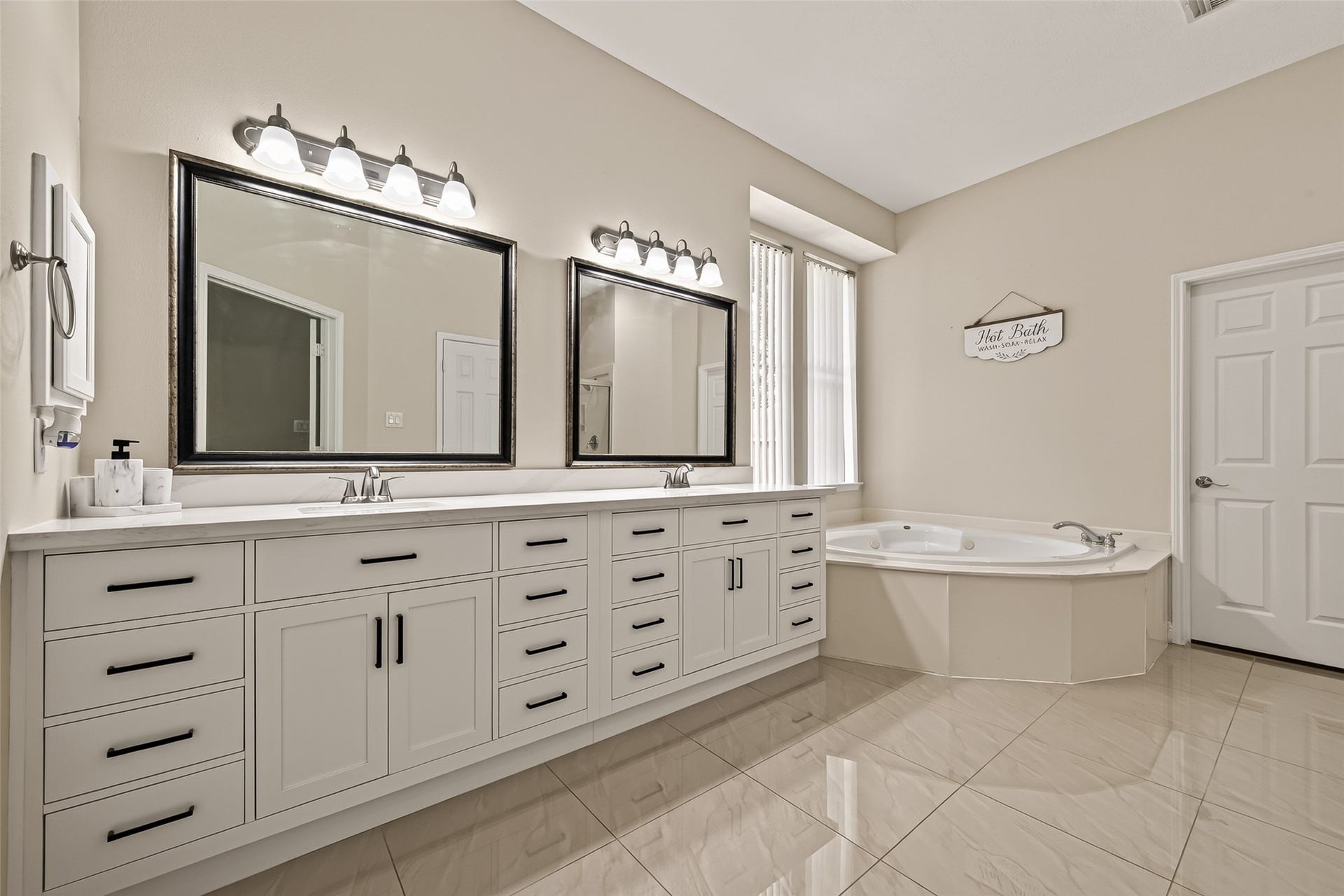 2002 Thorncrest Court, Sugar Land, TX 77479 Another View of the Primary Bathroom, Featuring a Double Vanity with Elegant Lighting, Ample Storage, and a Relaxing Corner Soaking Tub.