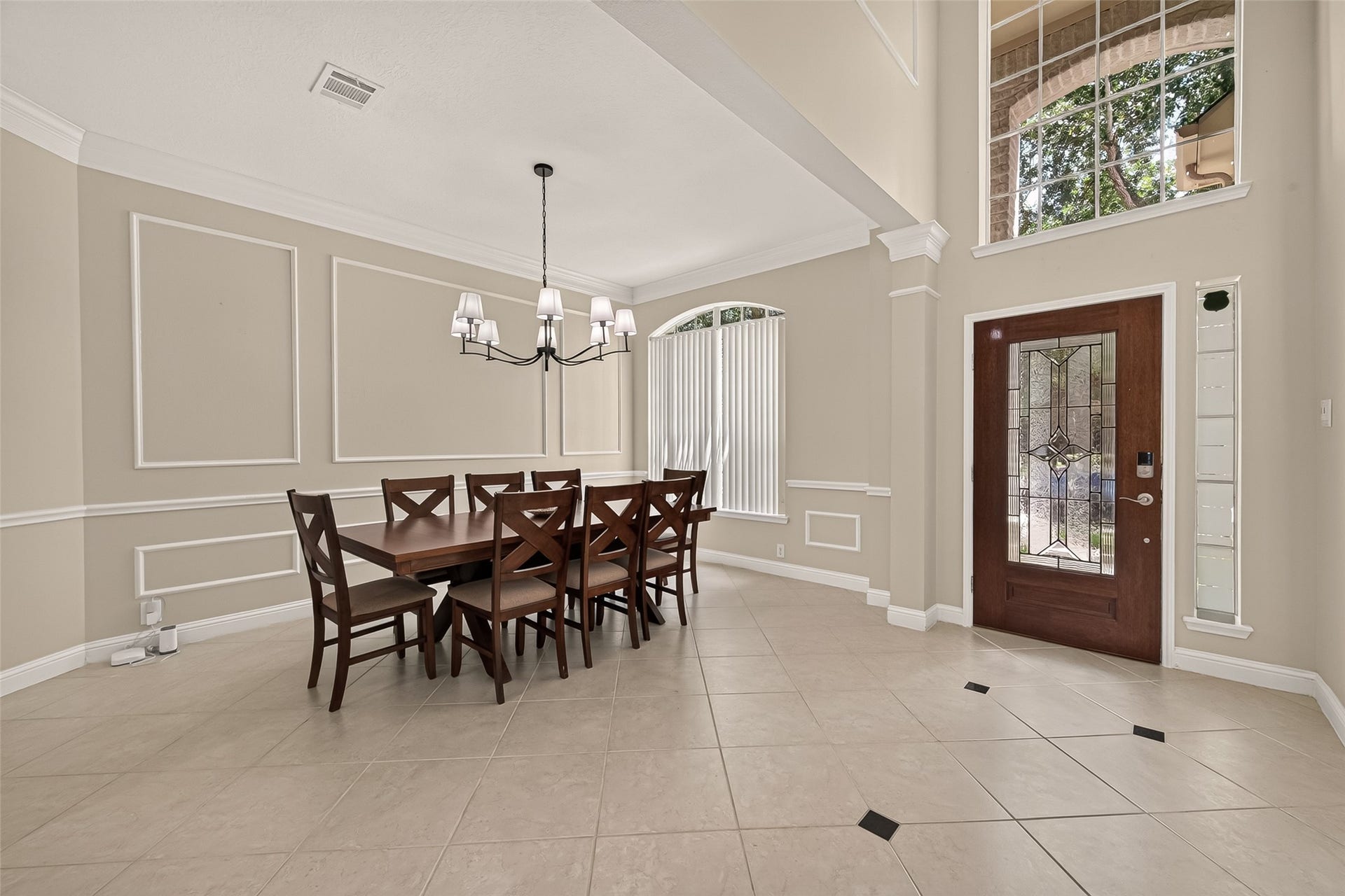 2002 Thorncrest Court, Sugar Land, TX 77479 Dining area with high ceilings, featuring a spacious table, a stylish chandelier, and abundant natural light from large windows.