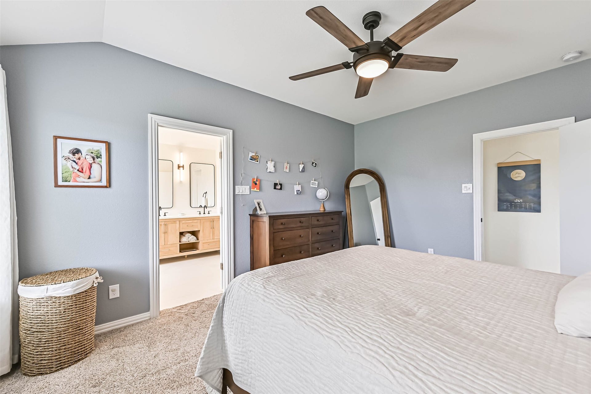 A view of the primary bedroom with a glance into the primary bathroom.
