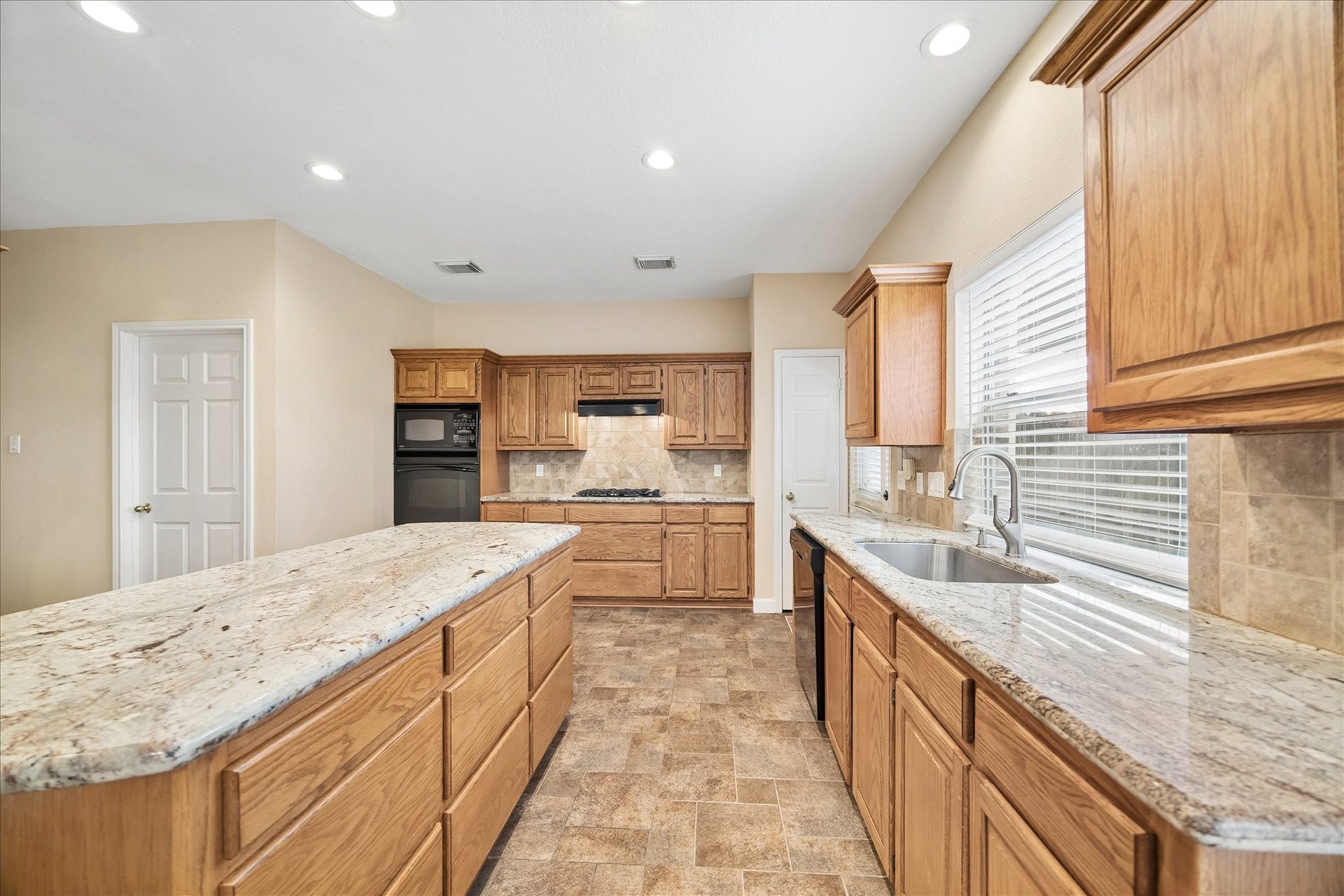 16715 Colony Terrace Drive, Sugar Land, TX 77479 The granite is just stunning! And backsplash. This kitchen is made for entertaining family and guests. Lots of storage. The door by the back door is a closet (could be a second pantry). The closed door on the left is the utility room. Across from that (you cannot see it) is the large walk-in pantry.