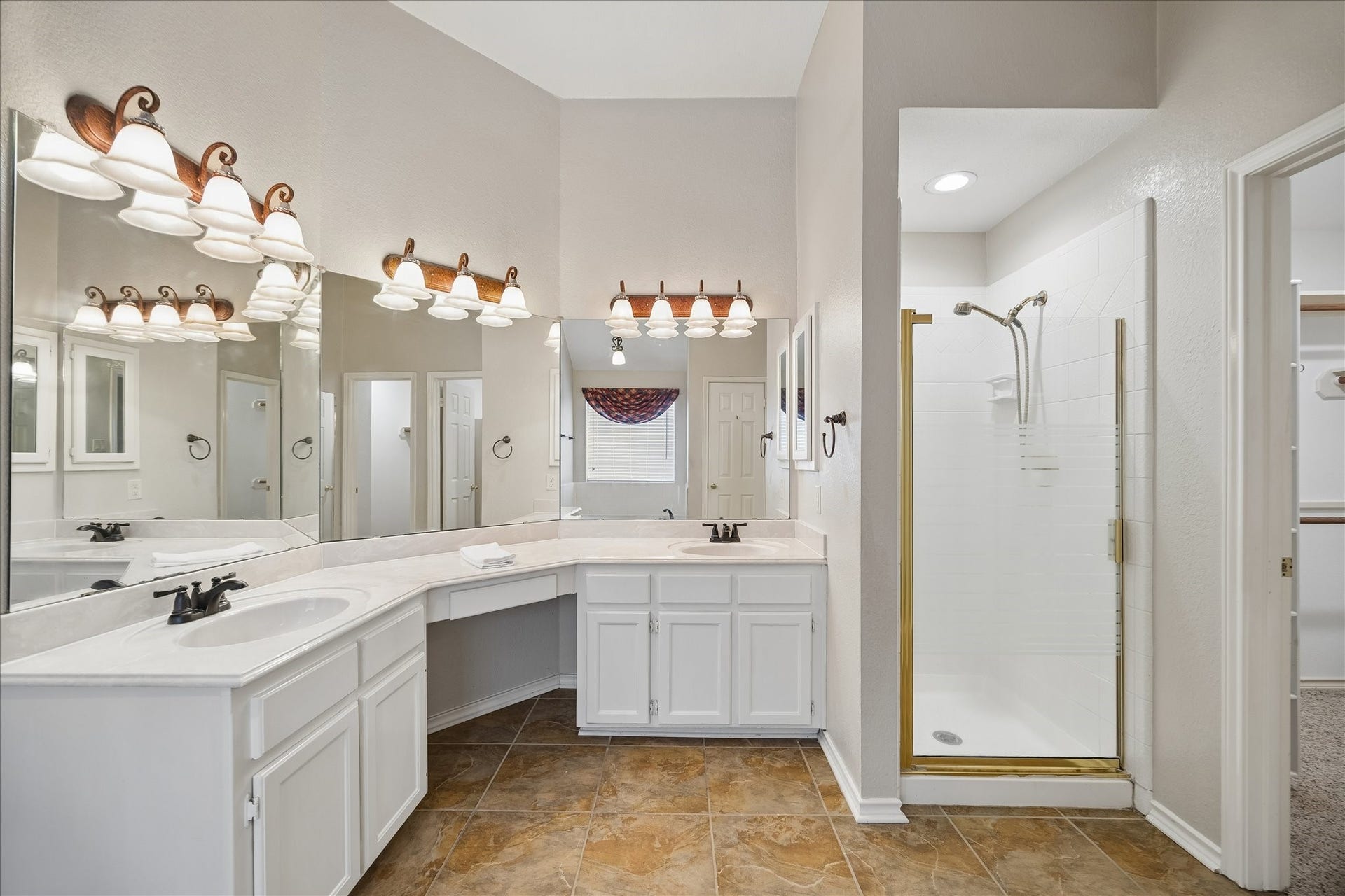 16715 Colony Terrace Drive, Sugar Land, TX 77479 You enter the primary bathroom to the left of this picture. Here you see the vanity and his and her sinks. Separate shower, and jetted tub behind. To the right of the shower is one of the 2 walk-in closets in the bathroom.