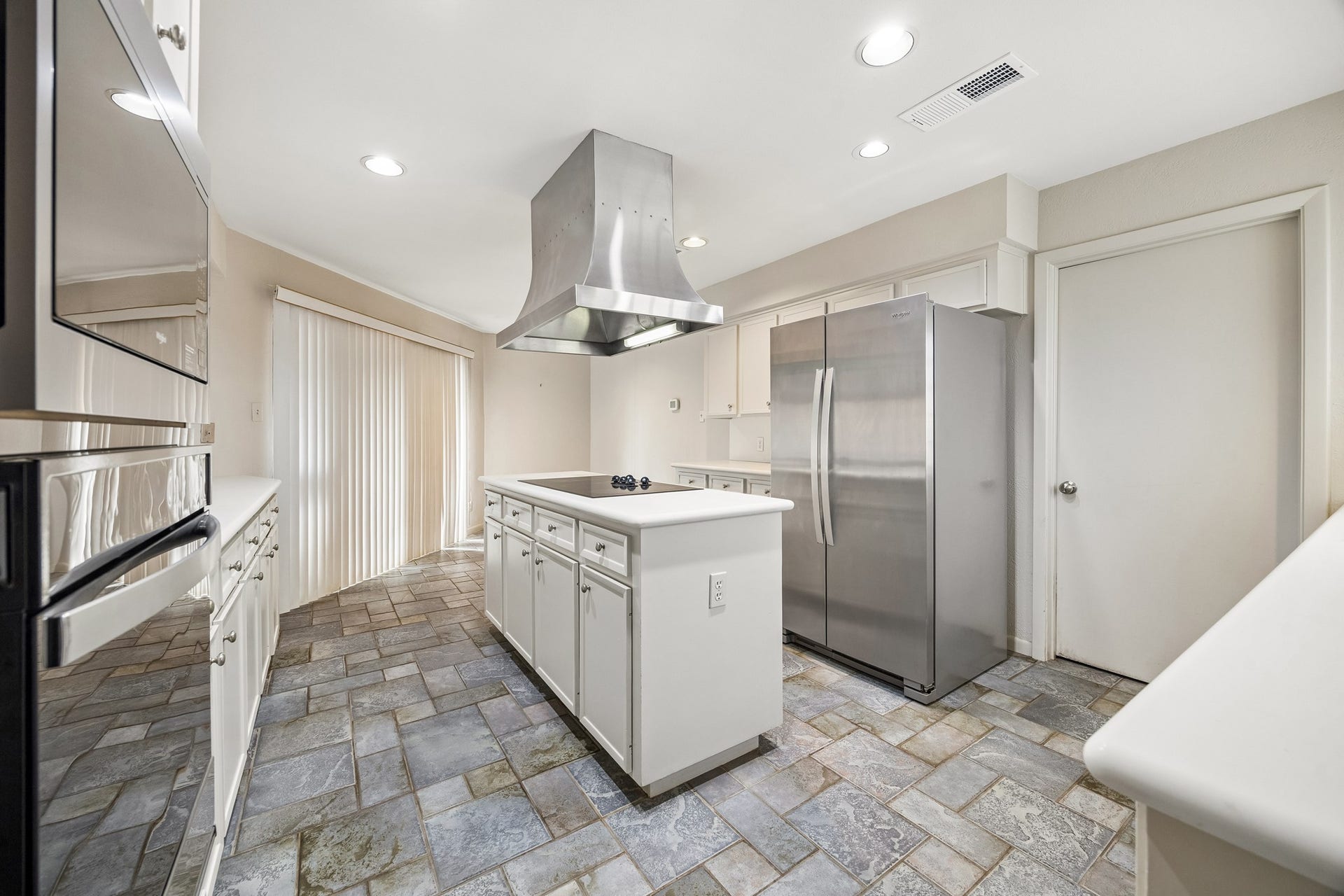 10327 Olympia Drive, Houston, TX 77042 The kitchen island offers abundant storage and breakfast nook with sliding doors to patio.