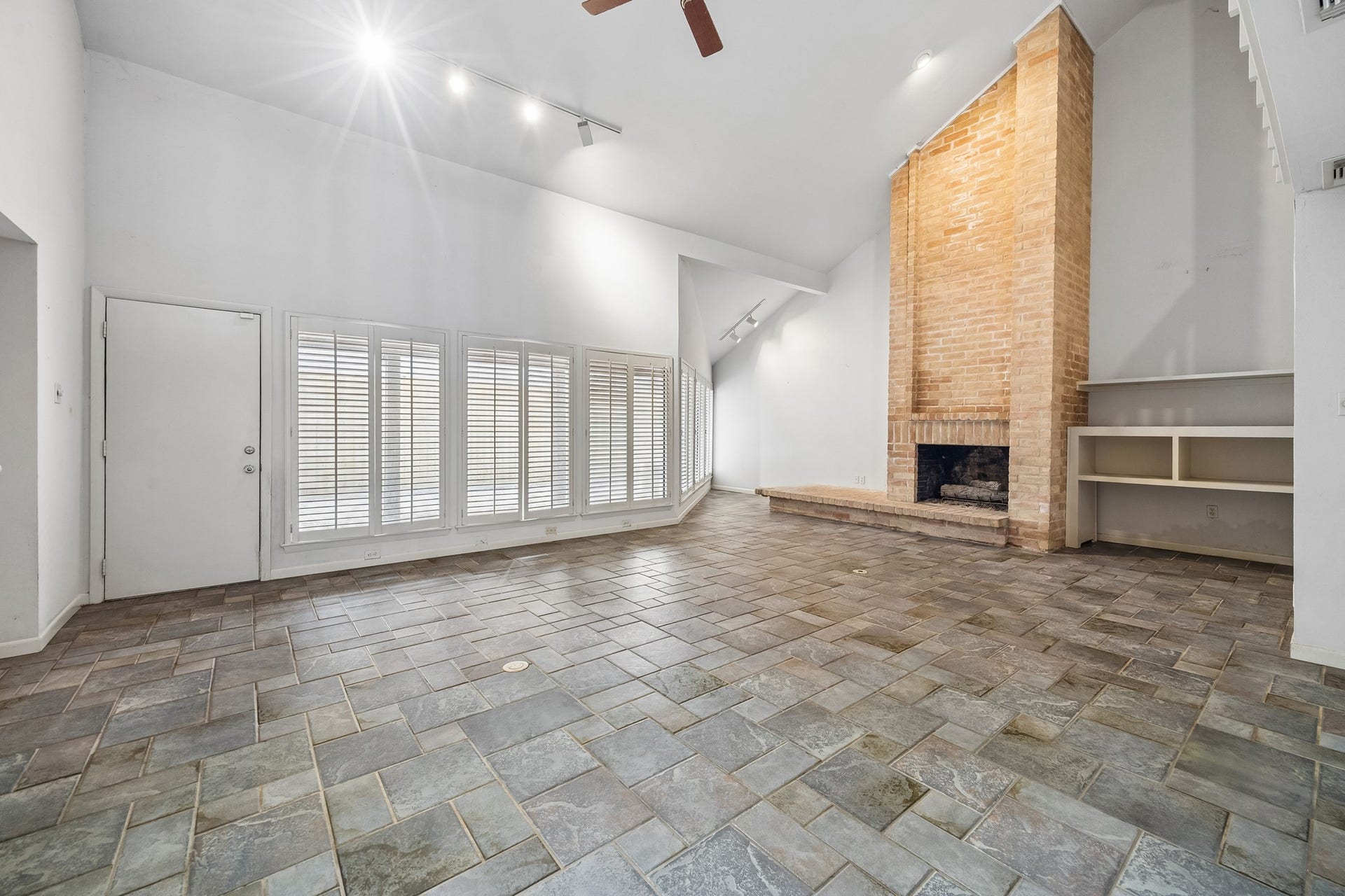 10327 Olympia Drive, Houston, TX 77042 The family room has complete wall of windows, soaring ceilings and lovely natural brick fireplace with gas connections.
