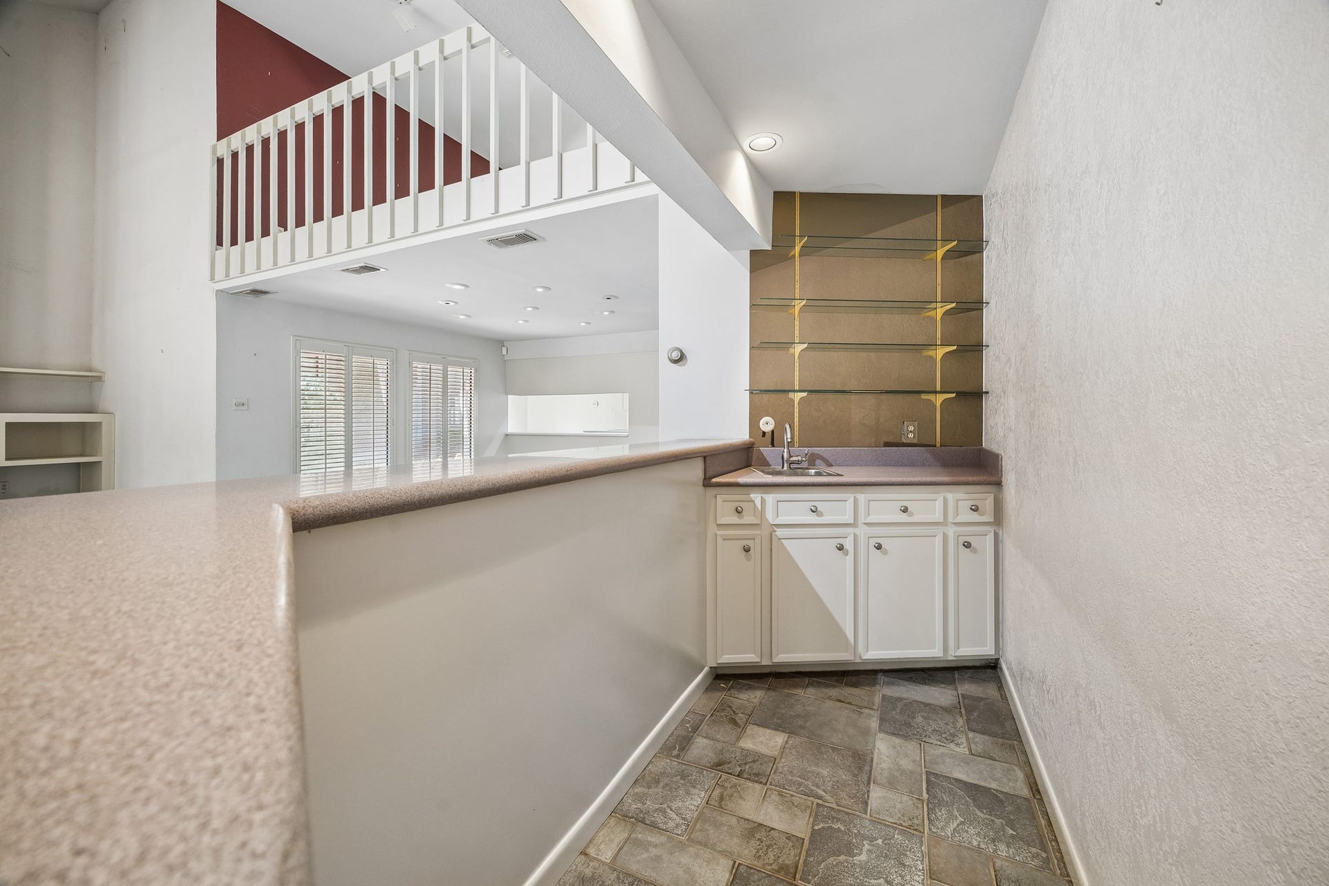10327 Olympia Drive, Houston, TX 77042 Behind the Bar is stainless bar sink, glass shelving and cabinets below.