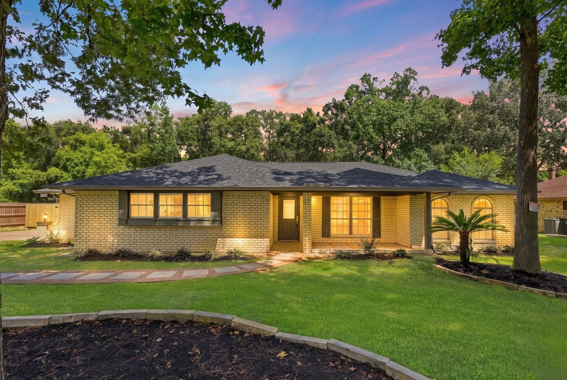 22077 Stoneridge Drive, Porter, TX 77365 Beautifully updated single-story home featuring exceptional curb appeal, mature trees, lush landscaping, and a welcoming covered front porch. The freshly refreshed exterior, modern dark accents, new roof, and inviting walkway create a warm first impression, while the expansive front yard highlights the property's spacious setting.