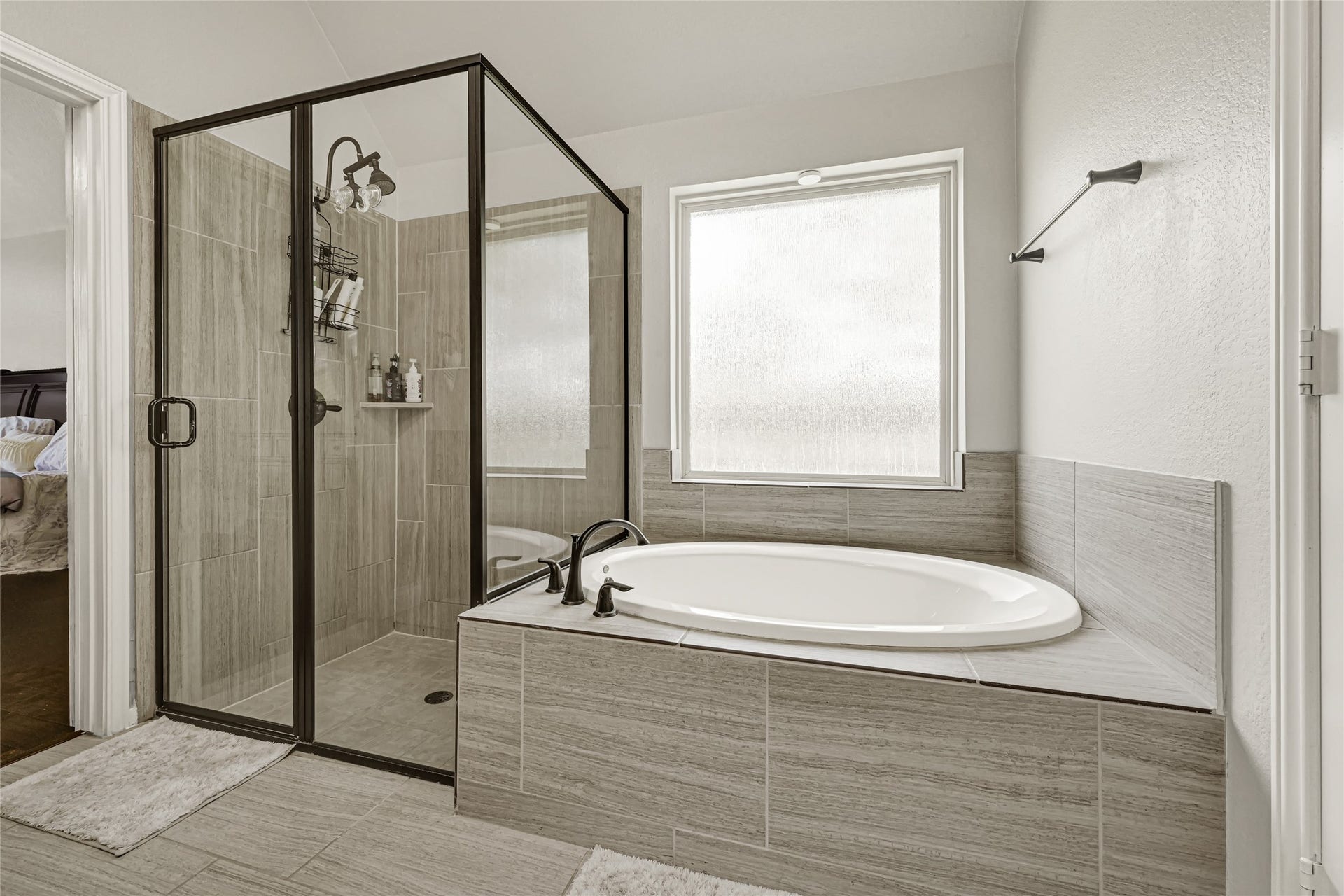 Experience ultimate relaxation in the primary bath, featuring a luxurious garden tub and a sleek standing shower, perfect for unwinding after a long day.