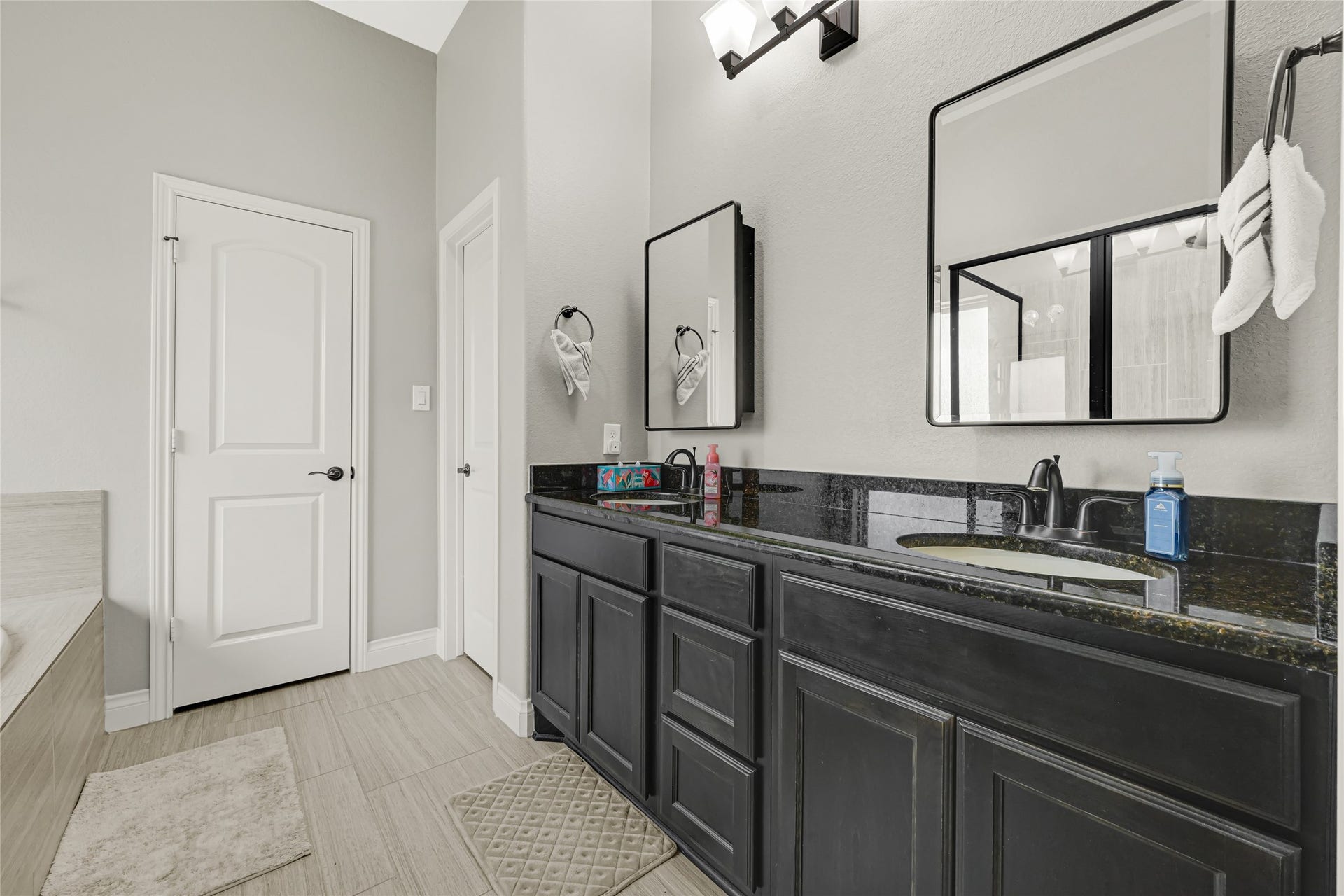 Experience luxury in the primary bath with double vanities and sleek mirrors, each featuring convenient cabinets for your essentials.