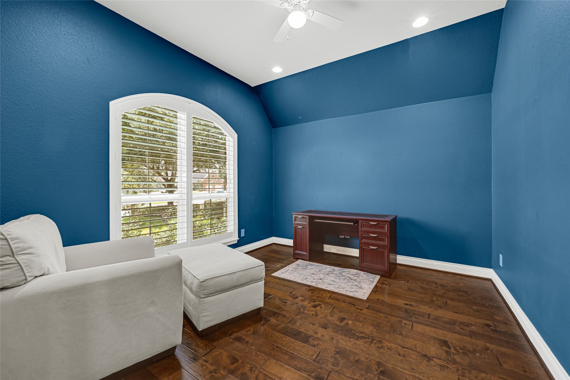 The study features elegant wood flooring and stylish Plantation Shutters, creating a warm and inviting atmosphere.