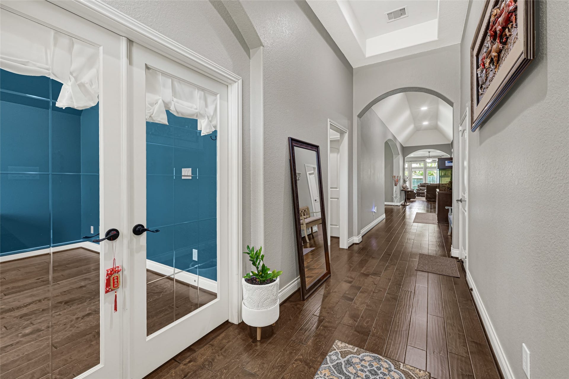 A grand entrance with rich wood flooring and soaring ceilings sets an inviting tone for this elegant home.