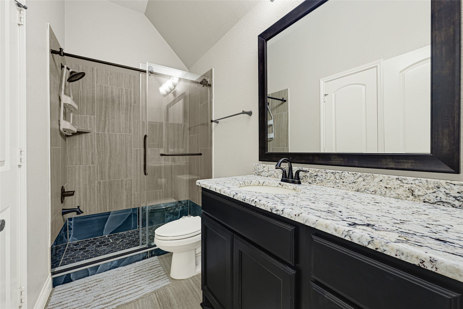 Experience comfort and style in this inviting bedroom, featuring sleek hardwood floors, abundant natural light, and a convenient full bath with a walk-in shower.