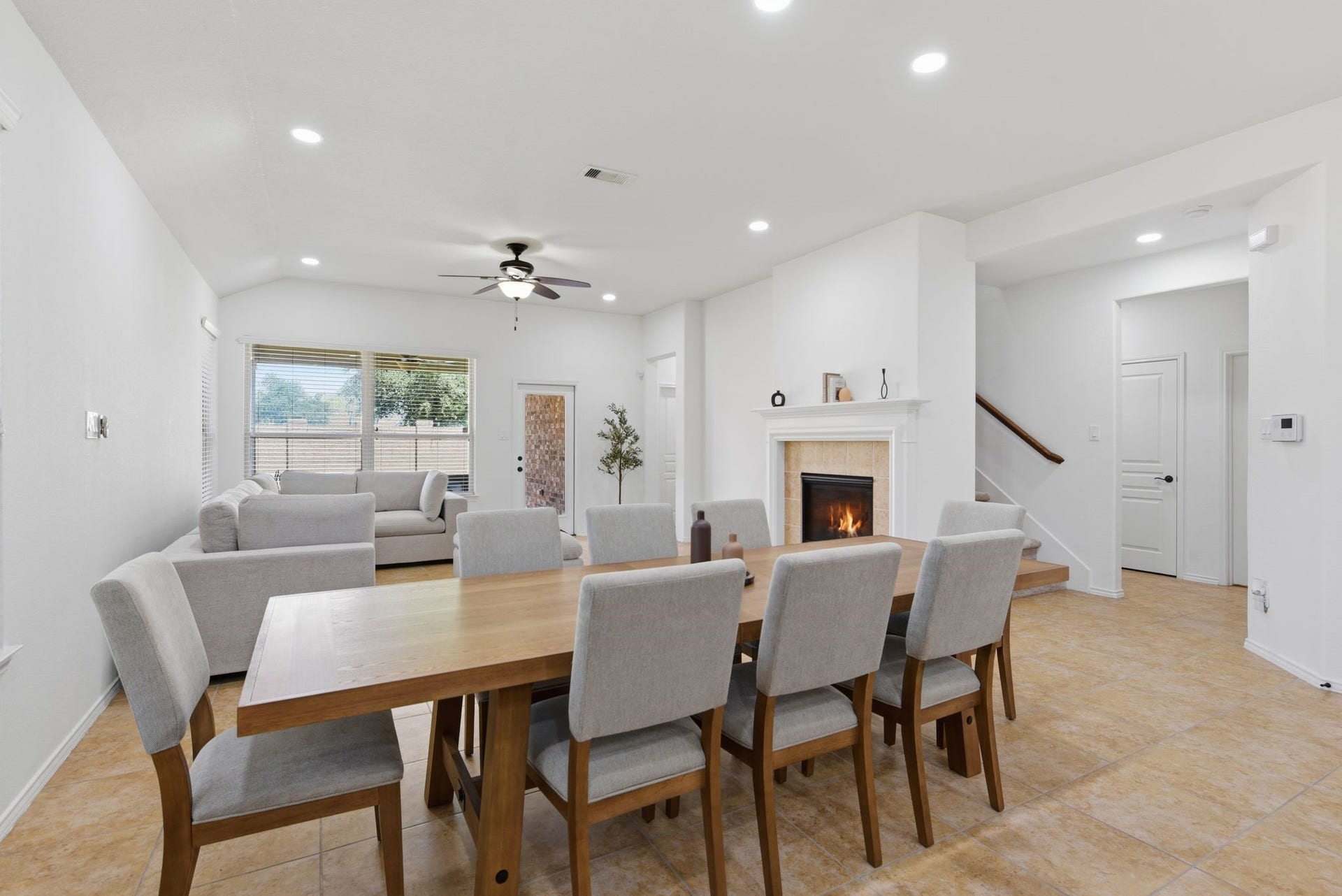 25322 Alverstone Drive, Katy, TX 77494 Spacious open-concept living and dining area with a cozy fireplace, large windows for natural light, and modern tile flooring.