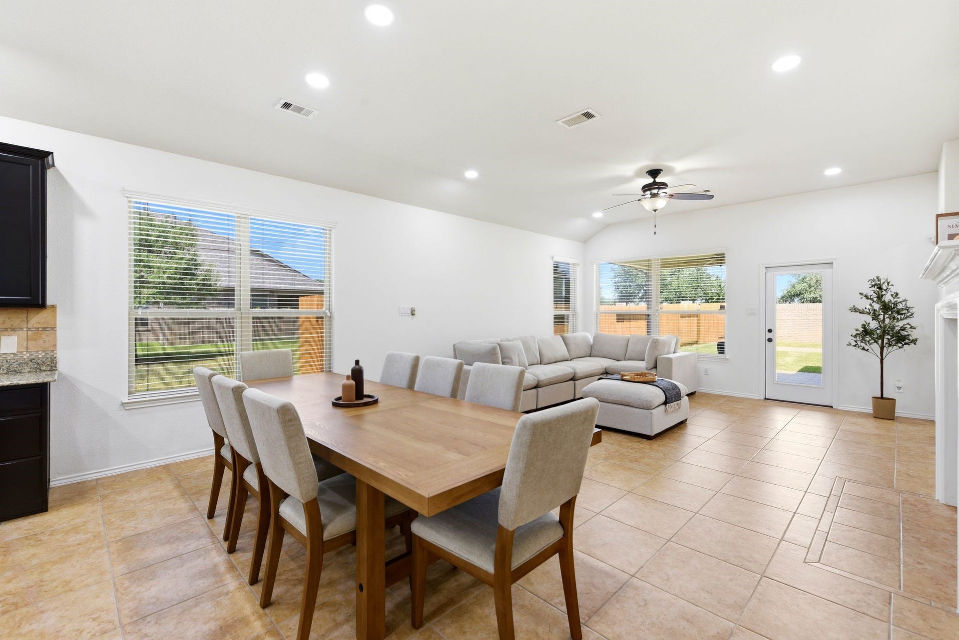 25322 Alverstone Drive, Katy, TX 77494 Spacious open-concept living area with abundant natural light, featuring a cozy sectional, ceiling fan, and elegant dining space, all overlooking the lush backyard.