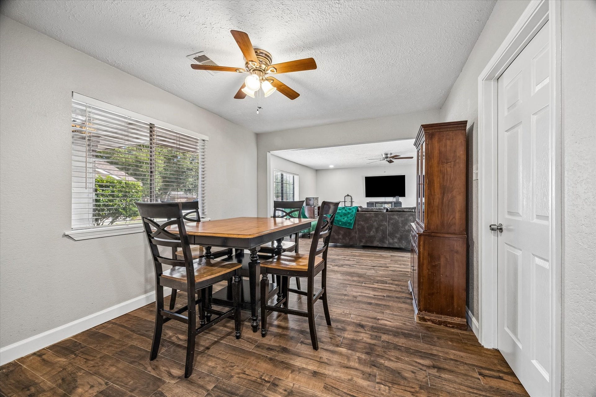 Functional dining area with warm tile floors and natural light, seamlessly flowing into a spacious living room perfect for entertaining.