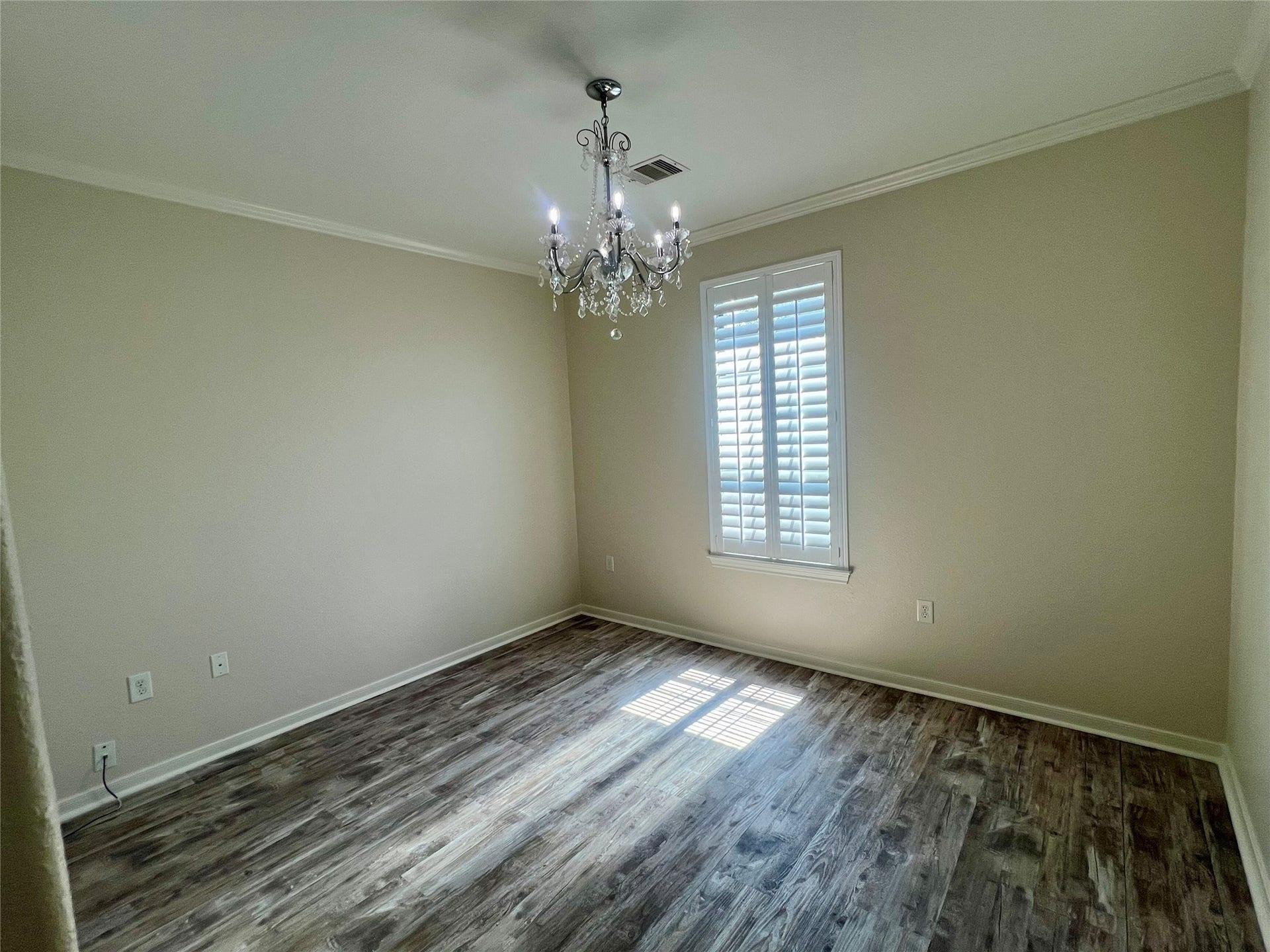 Front bedroom with nice chandelier and plantation shutters.