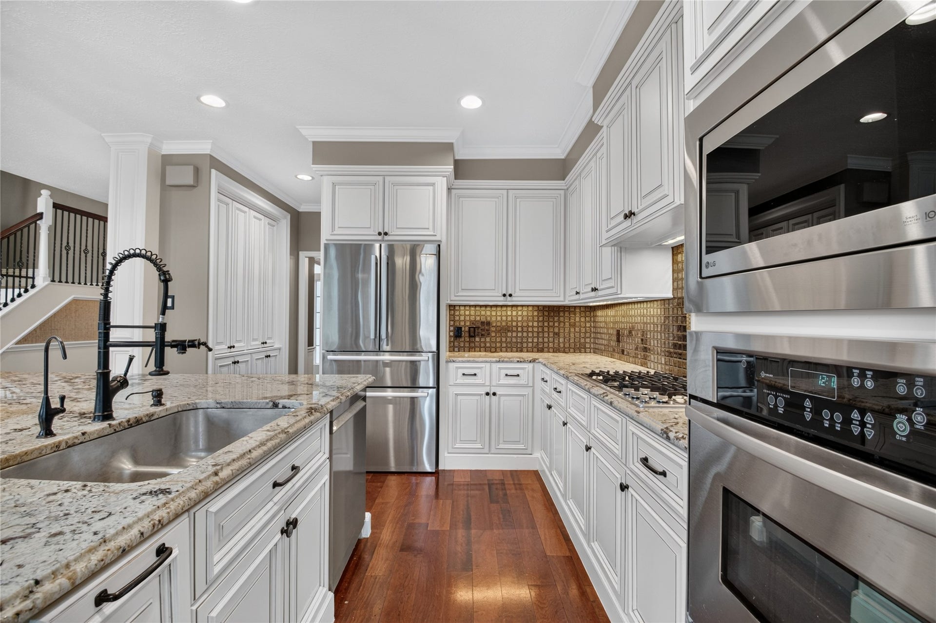 11810 Rue Beaujon Court, Tomball, TX 77377 Bright kitchen with white cabinetry, granite counters, gas cooking and stainless appliances. Refrigerator included.