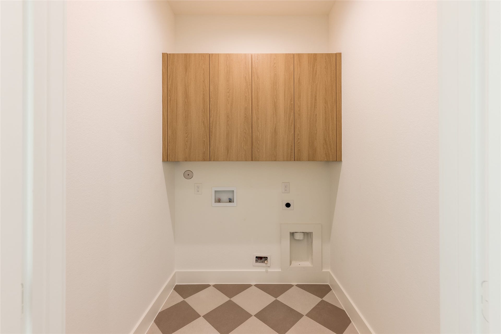 Utility are with modern checkered tiling and cabinets