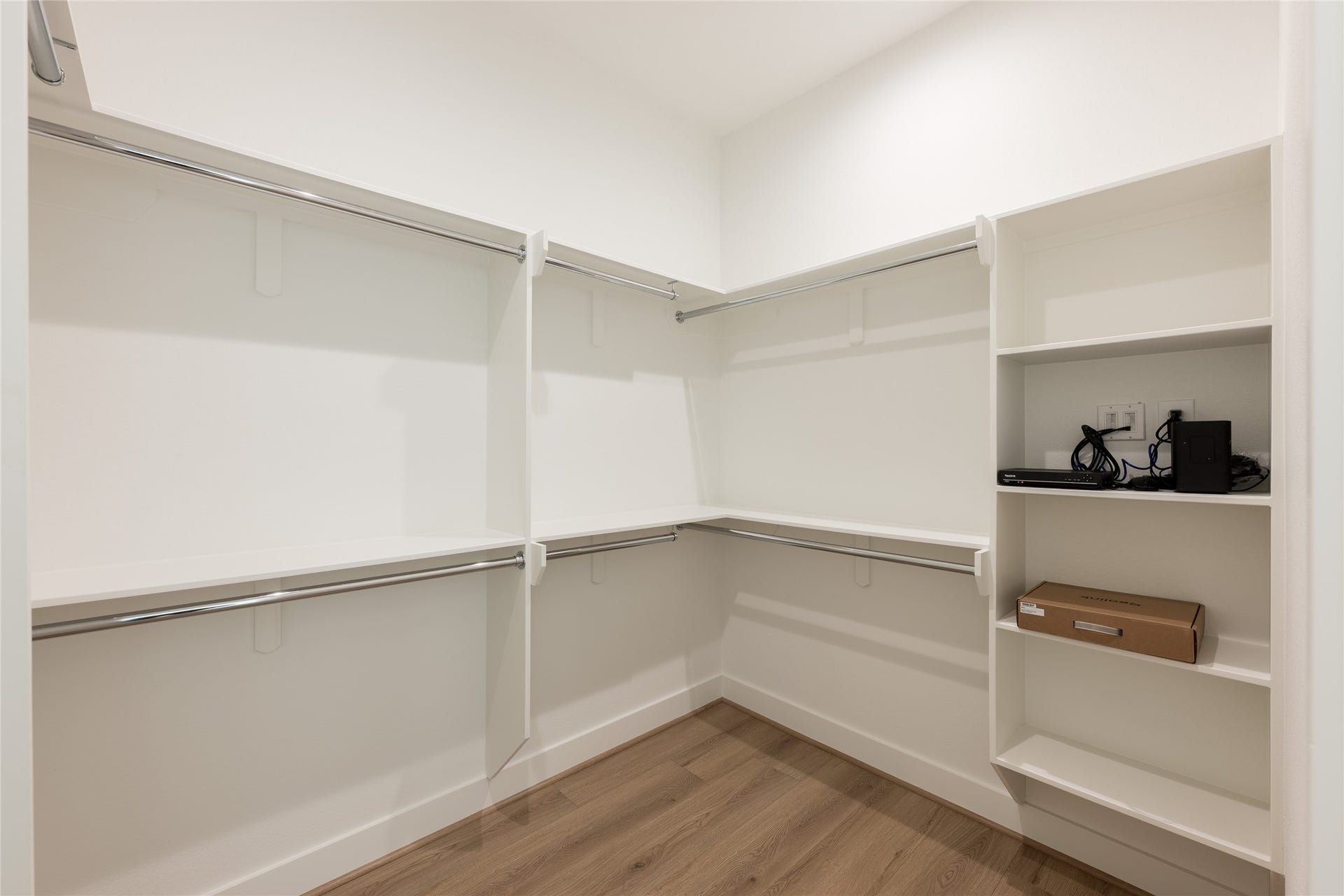 Spacious walk-in closet featuring ample hanging space and built-in shelving for organized storage.