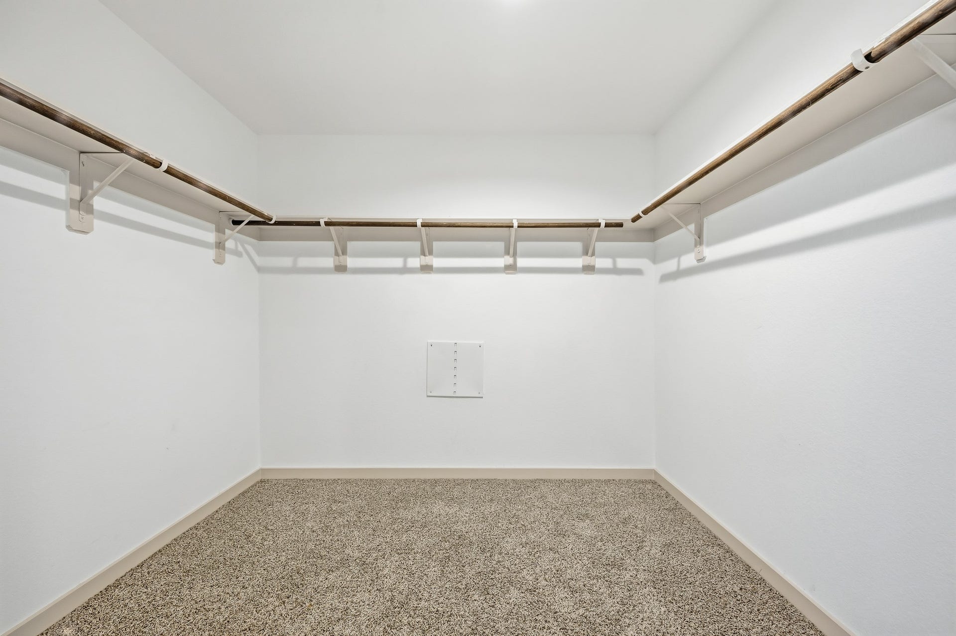 7002 Fleetwood Crescent Way, Richmond, TX 77407 Spacious walk-in closet with carpeted flooring, white walls, and multiple wooden hanging rods for ample storage.