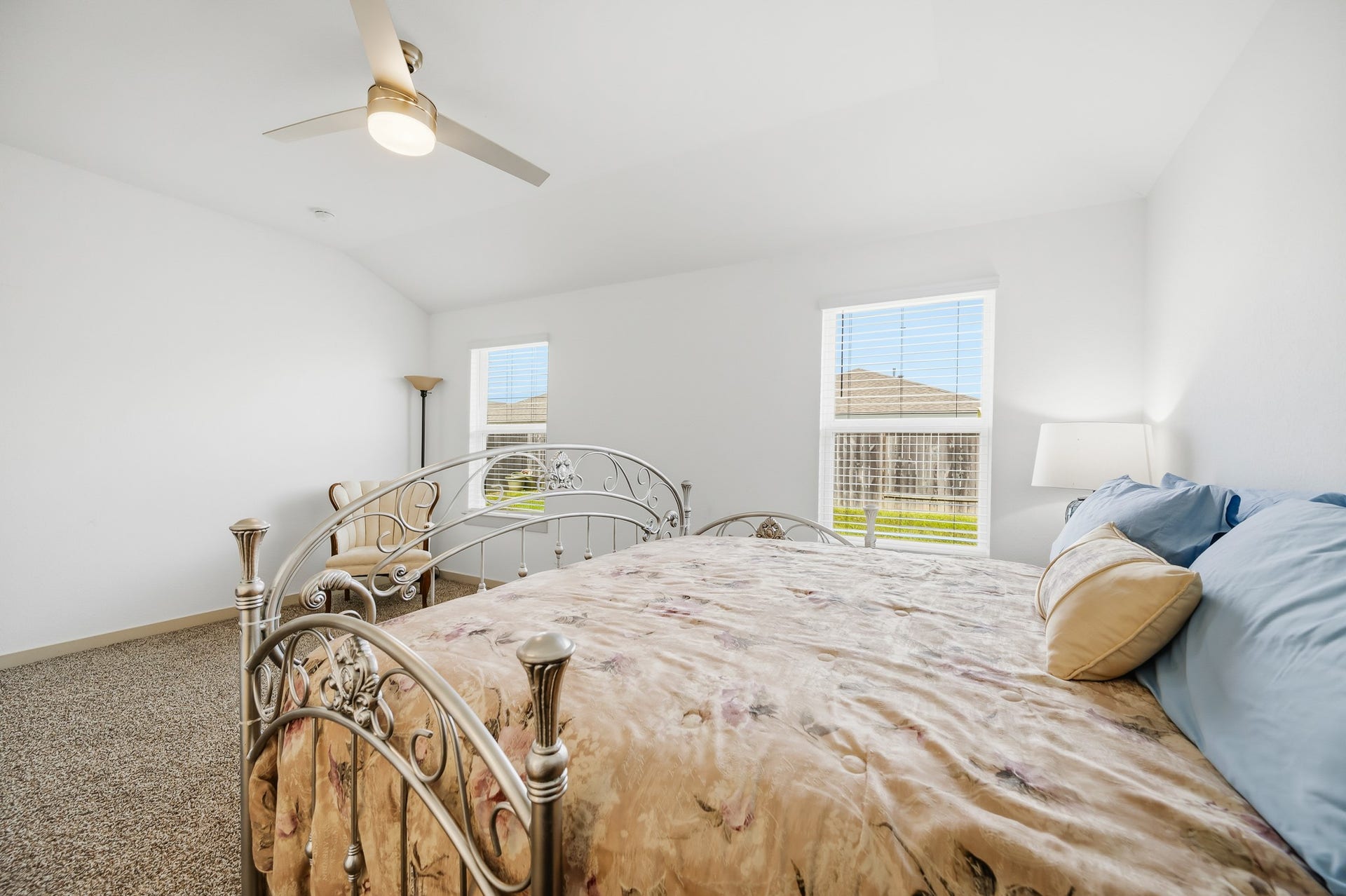 7002 Fleetwood Crescent Way, Richmond, TX 77407 This bright bedroom features a cozy carpeted floor, stylish metal bed frame, and large windows that let in ample natural light. The ceiling fan and neutral decor create a comfortable, airy atmosphere.