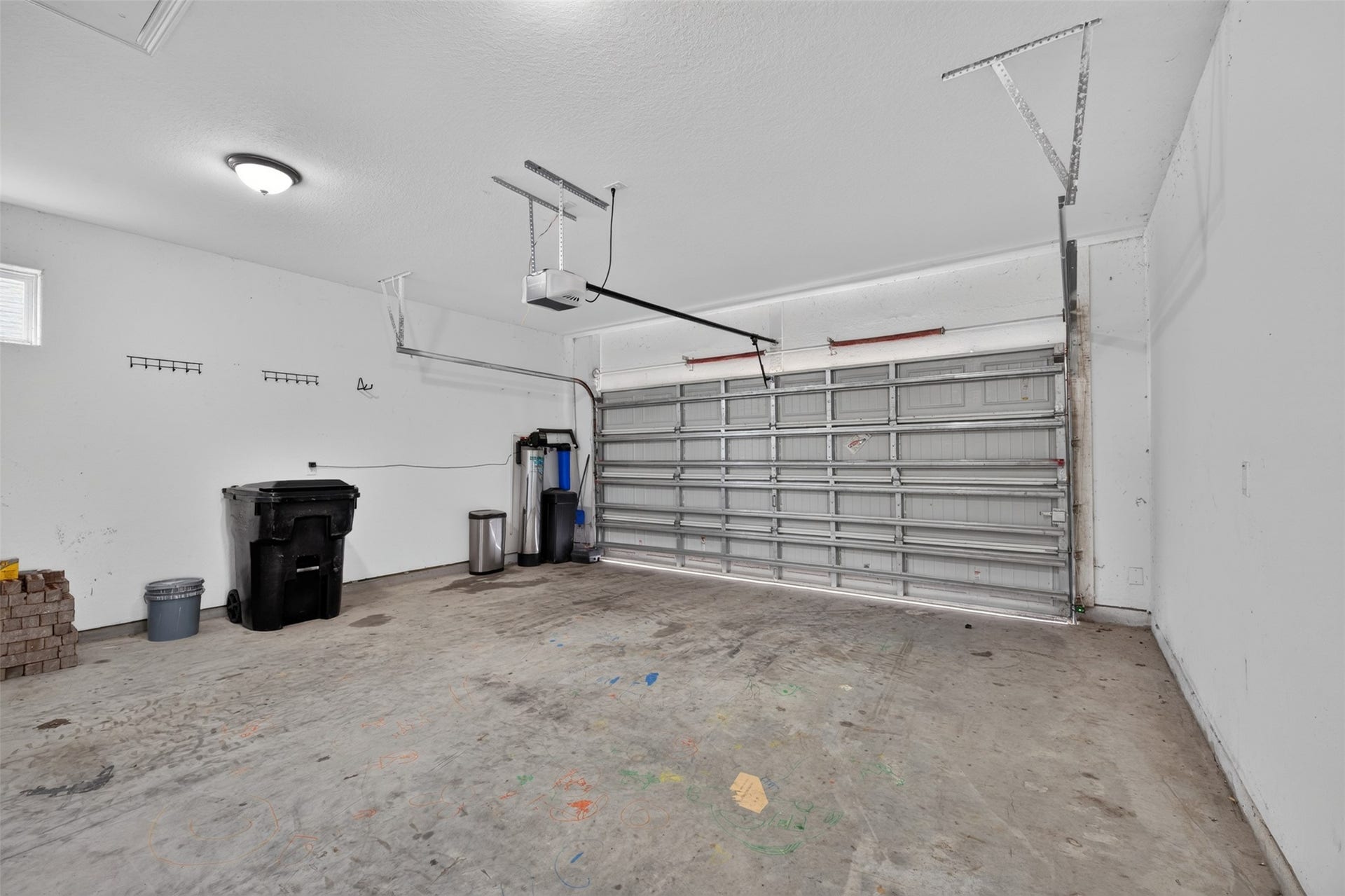 Spacious two-car garage with ample room for storage, featuring a durable concrete floor and convenient shelving for organization.
