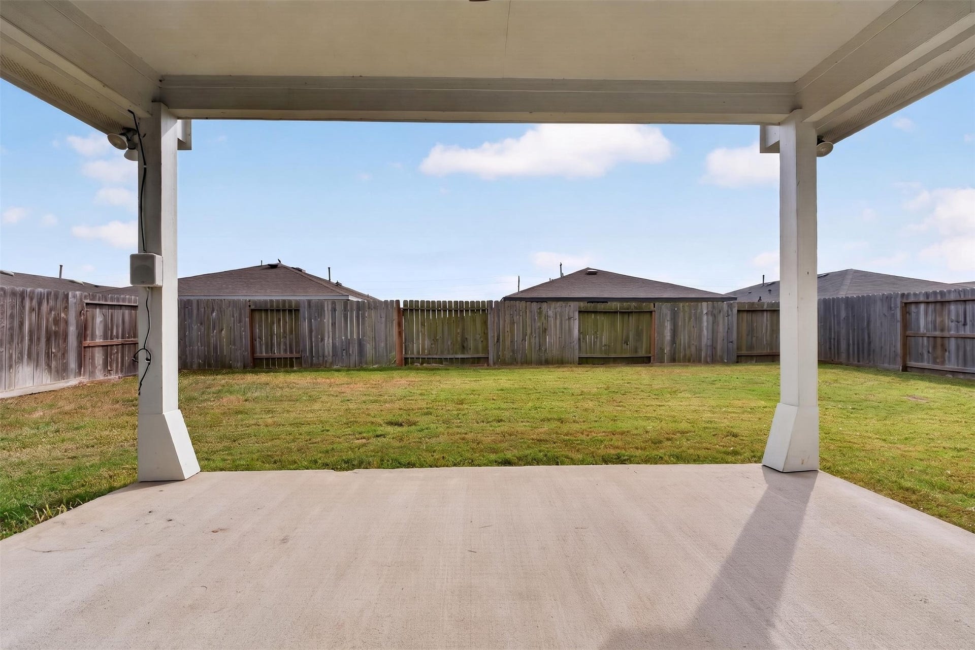 Spacious backyard with a covered patio, ideal for outdoor gatherings and relaxation.