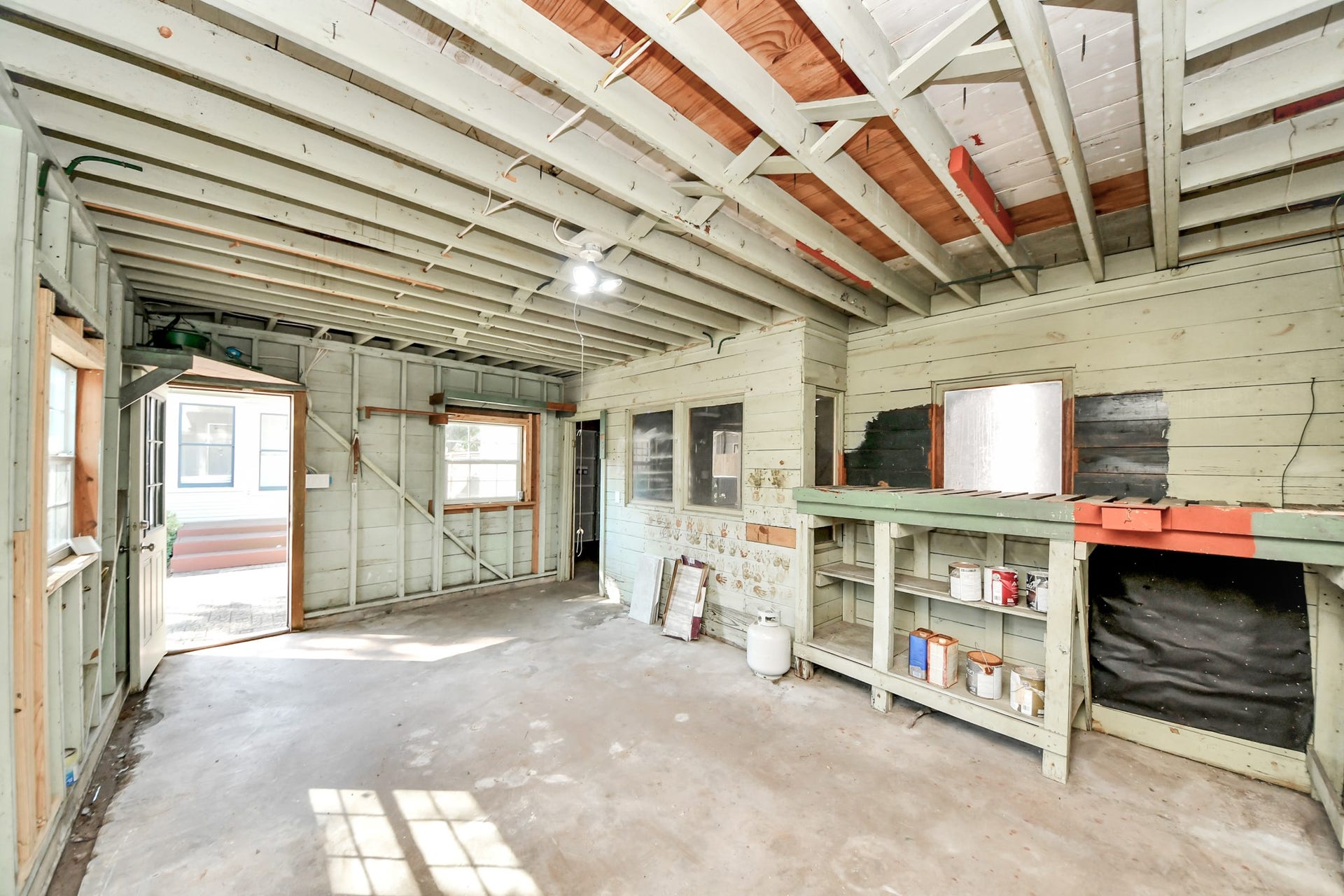 909 Fugate Street, Houston, TX 77009 Spacious garage storage room with ample shelving and natural light, perfect for organizing tools and equipment.