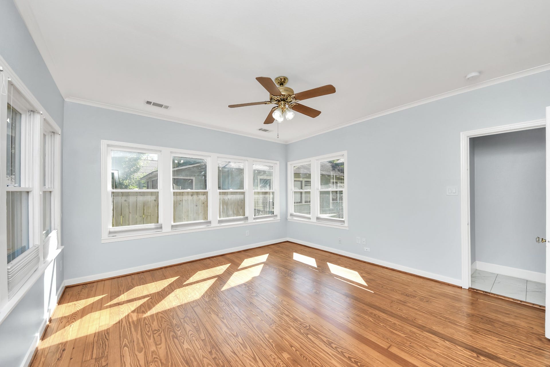 909 Fugate Street, Houston, TX 77009 Expansive and filled with natural light, the primary bedroom boasts elegant hardwood floors, large windows, and a stylish ceiling fan, creating a serene and inviting retreat.