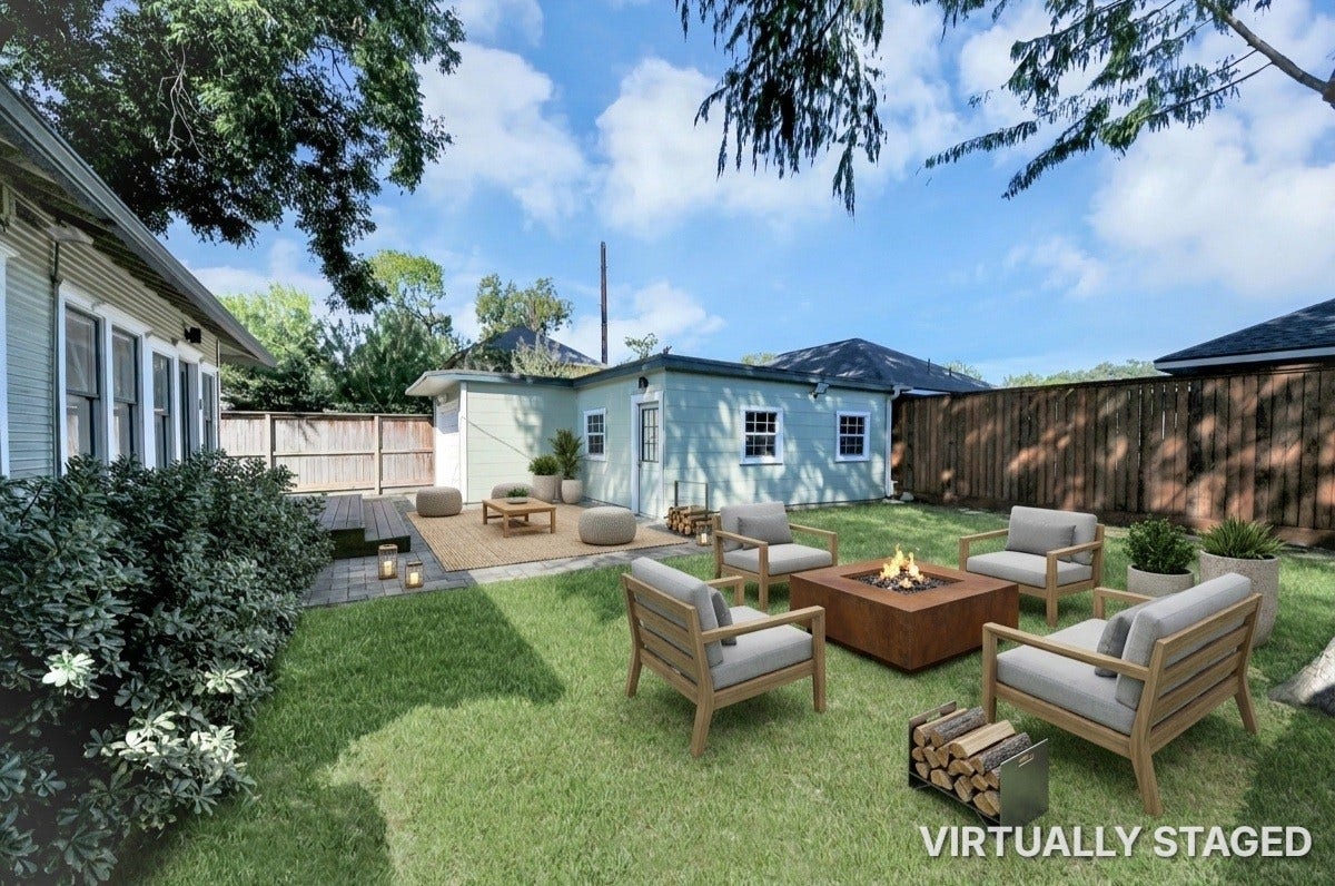 909 Fugate Street, Houston, TX 77009 Charming backyard oasis featuring a cozy fire pit area with comfortable seating, lush greenery, and ample space for relaxation or entertaining.
