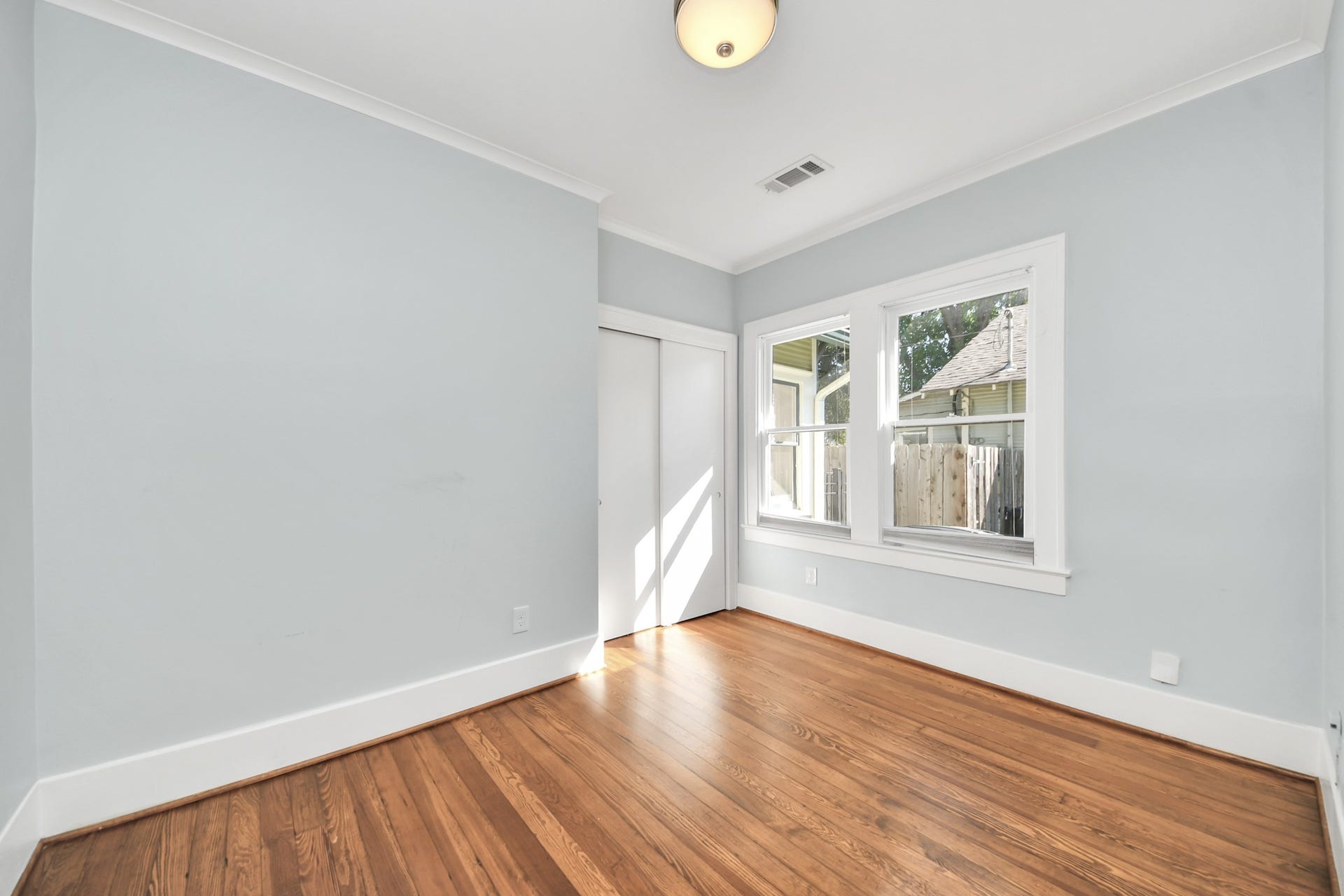 909 Fugate Street, Houston, TX 77009 Bright and inviting, Bedroom 2 features warm hardwood floors, ample natural light through double windows, and a sleek, modern design perfect for relaxation.